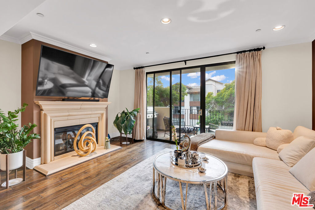 Welcome home to this premium luxury condominium building conveniently located in a prime pocket of Westwood. Enter into this upscale building through a fountain courtyard entrance filled with lush greenery and exquisite Mediterranean surfaces. As you enter into this west-facing, front and center dynamic unit you are immediately impressed by high ceilings, crown moldings, hardwood floors and a stunning row of reductive Roman-inspired colonnade that spatially separate the series of well-proportioned living areas. The chef kitchen flanked by the formal dining room on one side and the "bar area" and living room on the other, is a dream-come-true fully equipped with stainless steel Viking appliances, travertine backsplash, granite countertops and oak cabinetry. Depending on the mood, effortlessly serve your guests in the formal dining room or in the bar area and living room leading to the spacious balcony where BBQ is being prepared. The living room with the stone fireplace flows easily into the spacious balcony through the double sliding doors creating an indoor-outdoor atmosphere for those dreamy LA nights. The split bedroom floor plan allows for maximum privacy between the two ensuite bedrooms. The completely enclosed and expansive luxury master suite boasts a double-sink vanity, a soaking tub, a luxury shower and an oversized walk-in closet. The master bedroom is equipped with a king-size bed that faces the balcony. Start your day by enjoying your morning coffee on the balcony that overlooks the Jacaranda-lined treetops in this tranquil street. Luxury guest bathroom at entry, side-by-side washer/dryer, two tandem parking spots, 7 guest parking spots in undercover garage and so much more !