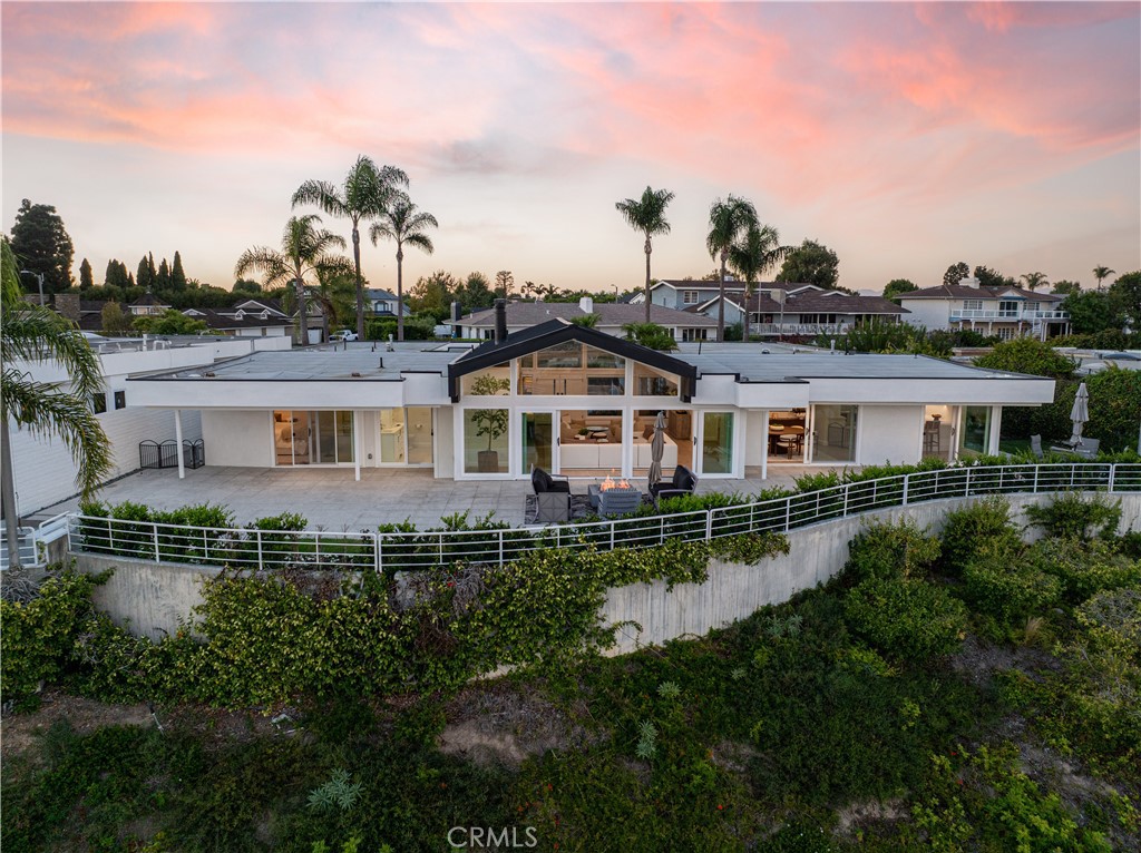 Located in the prestigious Dover Shores community, this almost completely renovated 4-bedroom, 4-bath home offers panoramic views of the Back Bay, ocean, Fashion Island, and city lights. Featuring soaring ceilings, floor-to-ceiling windows, and an open layout, the home includes a new kitchen with modern finishes, all-new bathrooms, 9-inch white oak flooring, new roof, HVAC, updated plumbing and electrical, new stucco and paint, and replaced sliding glass doors. A spacious entry courtyard leads to the living room with fireplace, a built-in bar with sink, mini fridge, and new countertop, plus a separate laundry room and large 3-car garage. The beautifully landscaped backyard and turnkey design make this home perfect for both everyday living and entertaining in the heart of Newport Beach.