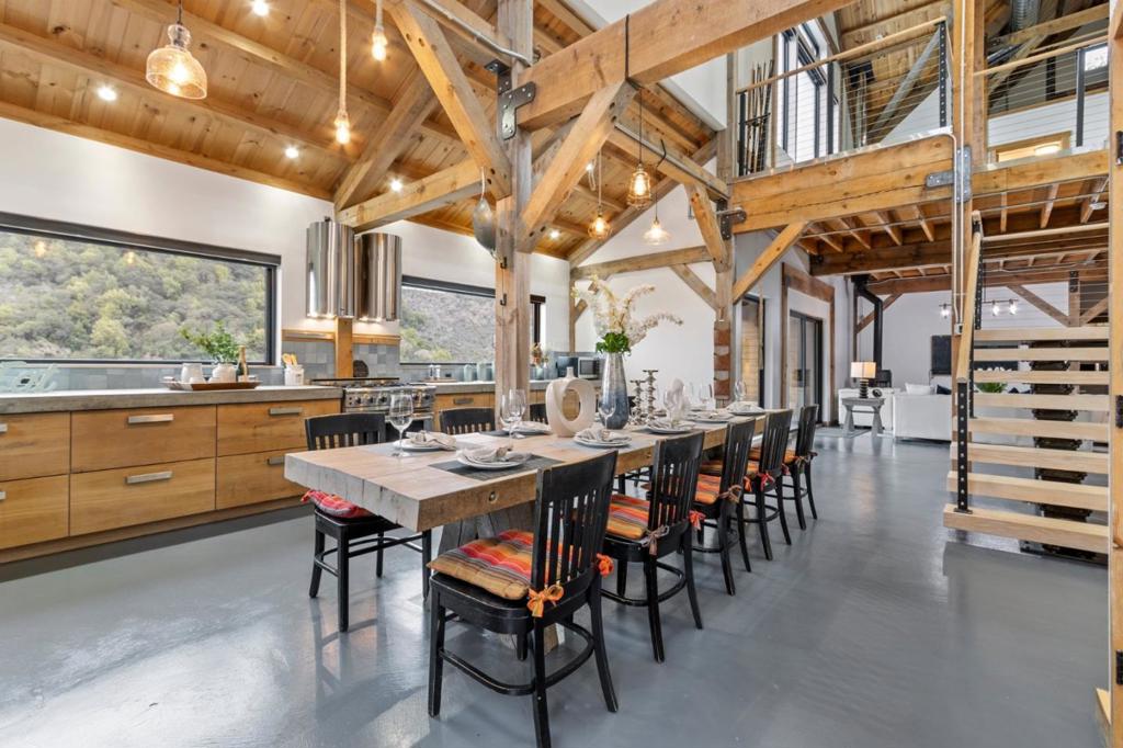 This stunning custom-engineered post-and-beam home offers breathtaking hilltop views. Nestled on three acres with over 100 oak trees, the home, built in 2019, boasts a large, south-facing deck that ensures privacy. A recently completed two-story detached studio offers space for an office, wine cellar, or creative studio. Excellent internet makes this an ideal work-from-home location. Inside, you'll find spacious, exposed wood beam ceilings, radiant in-floor heating, and a cozy wood-burning stove. The kitchen is a chef's dream, featuring concrete countertops, oak cabinetry, and professional-grade appliances. Expansive windows allow you to take in the incredible views. The first-floor master bedroom includes an open beam ceiling, a built-in closet wall, and a Japanese two-person sitting tub with views from the deck. A floating staircase leads to the second floor, where you'll find an oversized playroom surrounded by three bedrooms, each with convenient sinks. The third floor offers an open loft and cupola storage area. Plenty of parking spaces. There are too many unique features to fully describe!