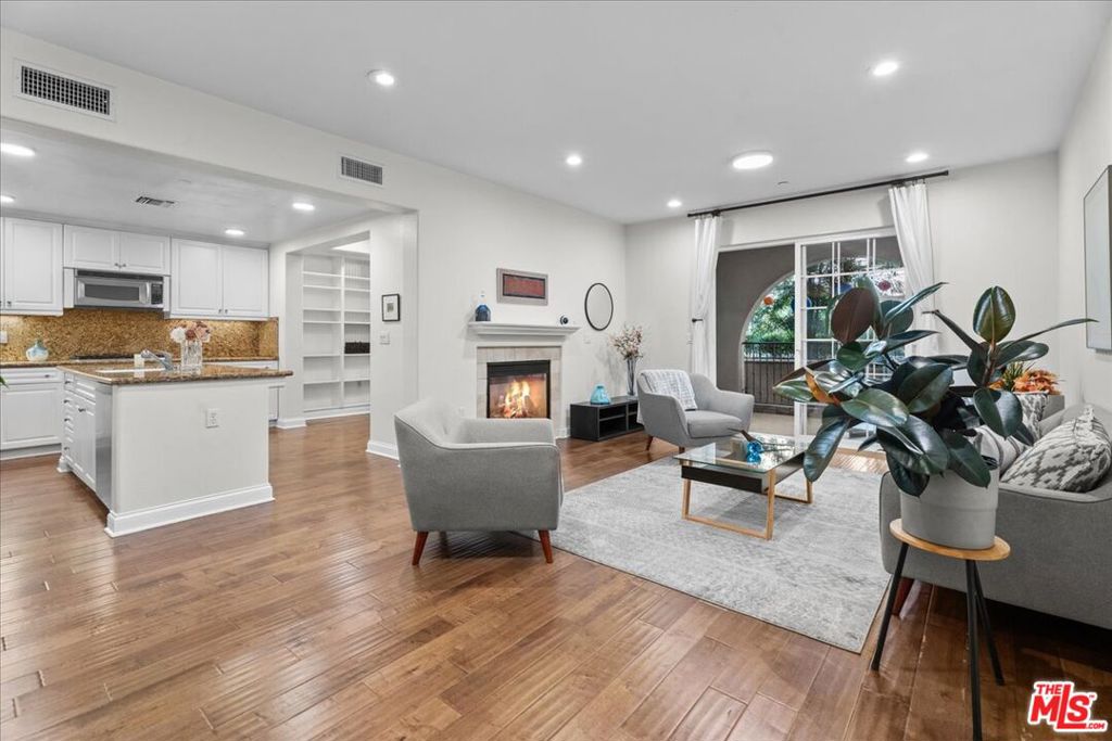 Tucked away on a peaceful cul-de-sac in the heart of Playa Vista, this beautiful 2-bedroom, 2.5-bath townhome-style condo offers the perfect blend of comfort, charm and modern convenience. Spanning 1,780 square feet, the residence lives like a standalone home with living and entertaining spaces on the first floor and bedrooms privately located upstairs. The thoughtfully designed open-concept layout welcomes you with distressed hardwood floors and stylish textured wall finishes. At the heart of the home is a gourmet kitchen featuring a large center island, granite countertops, stainless steel appliances, and crisp white cabinetry - ideal for both casual meals and entertaining. The adjacent dining area showcases custom built-in shelving, while a dual-sided gas fireplace provides an elegant transition between the dining and living rooms. Step beyond the living area to an oversized, covered patio that invites al fresco dining, morning coffee, or simply relaxing with a book. Upstairs, you'll find two spacious en-suite bedrooms. The serene primary suite features its own private balcony overlooking the tranquil courtyard, a generous walk-in closet, and a spa-like bathroom with both soaking tub and shower. The second bedroom also offers access to the balcony and a full en-suite bath. A conveniently located laundry closet completes the upper level. Additional features include side-by-side parking with an EV charger, full access to Playa Vista's coveted amenities, pool, fitness center, barbecue areas, and more - and included services such as high-speed internet, cable TV, and home security monitoring. Just a short stroll to Runway Playa Vista, Whole Foods, Cinemark, restaurants, retail, and Concert Park. Only minutes to LAX, Silicon Beach, and the Westside including Santa Monica, Venice, and Marina del Rey. This is modern coastal living at its finest!