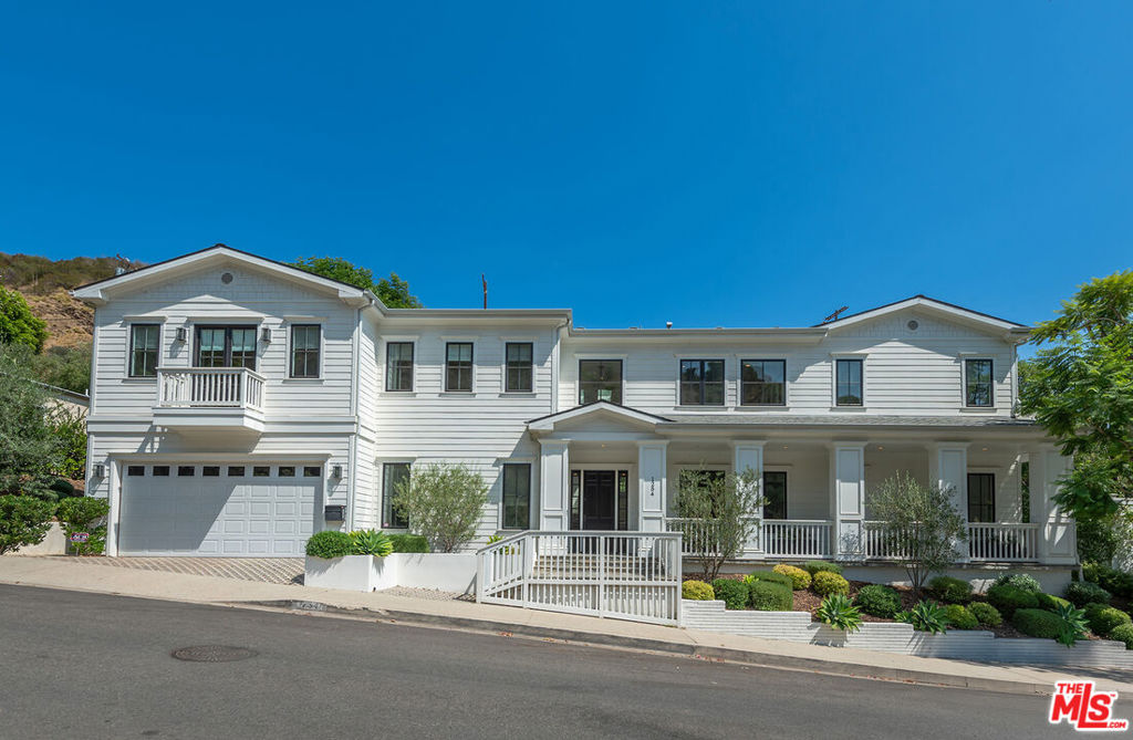 Spectacular newer built Hamptons Traditional offering nearly 4600 square feet of beautifully customized living space. Designed with exceptional flair and high end finishes, this 5 bedroom residence with office and versatile media or playroom combines timeless elegance with modern comfort. A dramatic two story foyer welcomes you into light filled interiors with an inviting open flow, soaring ten foot ceilings, and abundant natural light. The main level showcases a warm and gracious layout perfect for both gatherings and entertaining, featuring living, dining, and great rooms. The gourmet kitchen is a chef's dream, appointed with stainless steel appliances, butler's pantry, and custom French Oak hardwood flooring. The primary suite is a true retreat with a pitched ceiling, crafted woodwork, two oversized custom closets, and a luxurious spa inspired bath. Three additional upstairs bedrooms each include ensuite baths, while a spacious sunlit landing doubles as a play area or den. Additional amenities include a downstairs guest suite, private office, practical upstairs laundry, and an expansive media or playroom complete with a built-in wine fridge. Outdoor living shines with a sparkling pool and spa, built in barbecue bar, and a completely reimagined backyard designed for relaxation and entertaining. Olive trees with dramatic focal lighting, custom coyote fencing, and a remote operated irrigation system enhance the serene setting. Thoughtful upgrades abound, from Phillip Jeffries and Kelly Wearstler wall coverings to Waterworks bath fixtures, custom cabinetry and bookcases, glass panels and doors, a bespoke mudroom, garage storage, and exterior cameras. This Brentwood gem sits on a peaceful tree lined street with inviting curb appeal and front porch charm, blending luxury, practicality, and modern sophistication in one exceptional home.