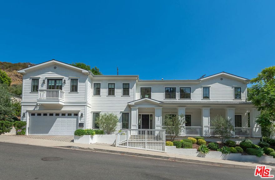 Spectacular newer built Hamptons Traditional offering nearly 4600 square feet of beautifully customized living space. Designed with exceptional flair and high end finishes, this 5 bedroom residence with office and versatile media or playroom combines timeless elegance with modern comfort. A dramatic two story foyer welcomes you into light filled interiors with an inviting open flow, soaring ten foot ceilings, and abundant natural light. The main level showcases a warm and gracious layout perfect for both gatherings and entertaining, featuring living, dining, and great rooms. The gourmet kitchen is a chef's dream, appointed with stainless steel appliances, butler's pantry, and custom French Oak hardwood flooring. The primary suite is a true retreat with a pitched ceiling, crafted woodwork, two oversized custom closets, and a luxurious spa inspired bath. Three additional upstairs bedrooms each include ensuite baths, while a spacious sunlit landing doubles as a play area or den. Additional amenities include a downstairs guest suite, private office, practical upstairs laundry, and an expansive media or playroom complete with a built-in wine fridge. Outdoor living shines with a sparkling pool and spa, built in barbecue bar, and a completely reimagined backyard designed for relaxation and entertaining. Olive trees with dramatic focal lighting, custom coyote fencing, and a remote operated irrigation system enhance the serene setting. Thoughtful upgrades abound, from Phillip Jeffries and Kelly Wearstler wall coverings to Waterworks bath fixtures, custom cabinetry and bookcases, glass panels and doors, a bespoke mudroom, garage storage, and exterior cameras. This Brentwood gem sits on a peaceful tree lined street with inviting curb appeal and front porch charm, blending luxury, practicality, and modern sophistication in one exceptional home.