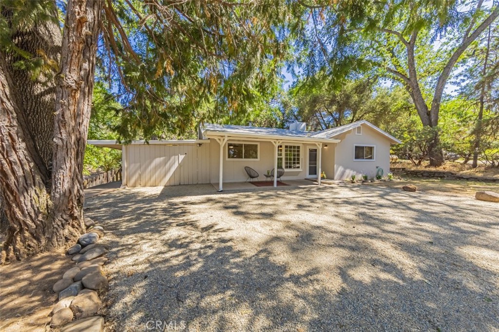 Welcoming country style home on a peaceful, tree-shaded lot! Tucked away on a quiet cul-de-sac this inviting move-in ready modestly sized 3 bedroom and 2 bath home offers a wonderful balance of comfort and simplicity. With 1,400+/- sq. ft. of living space, the home sits on over 0.55+/- acres shaded by mature trees that provide natural privacy and year-round comfort as well as a peaceful setting with ample outdoor space for relaxation or gardening. Recently updated with new interior paint inside and out along with new flooring throughout. The home is within close proximity to both downtown Oakhurst and community schools. The spacious fenced yard offers great space for animals along with a covered front porch and back patio area to sit and unwind. Whether you’re looking to settle into your first home or downsize, this inviting property is charming and practical. Offering a peaceful lifestyle with just a short drive to either Bass Lake and Yosemite, the home offers a blend of tranquility and convenience.