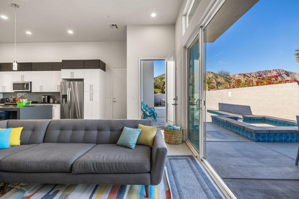 This modern retreat is designed to impress at every turn. With a seamless open floor plan, it blends indoor comfort with outdoor living, ideal for both everyday enjoyment and elegant entertaining. Striking details include a custom fireplace, subway tile backsplash, stainless steel appliances, soaring 12-foot ceilings, and 8-foot doors throughout. The chef's kitchen is the centerpiece, anchored by a dramatic quartz waterfall island perfect for hosting gatherings of any size.The primary suite offers a true escape, showcasing panoramic mountain views, direct access to the private hot tub, and a spa-inspired bath with dual quartz vanities and a custom-tiled walk-in shower. Outdoors, the resort-style pool area provides abundant space for dining and lounge seating, all framed by breathtaking sunset views.After a day exploring nearby hiking trails, dining, shopping, and local art fairs, return home to unwind beneath the stars from your patio or soak in the serenity of your spa. A rare opportunity to own a contemporary desert sanctuary awaits--schedule your private showing today.