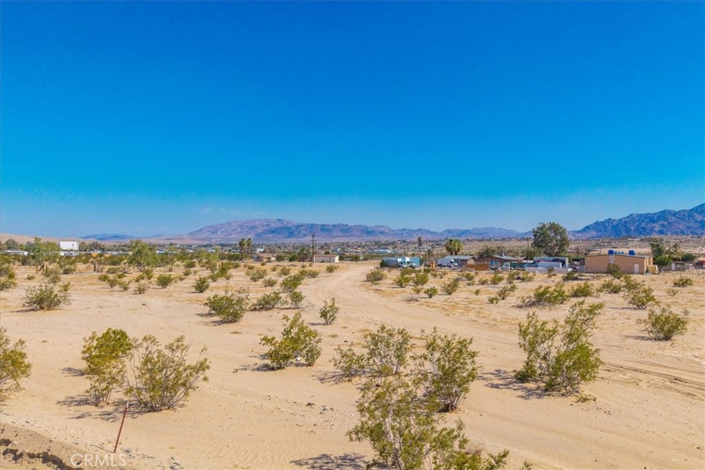 Located in a quiet Twentynine Palms neighborhood near Smith's Ranch, this 99,316 square foot parcel offers a spacious opportunity for those looking to build a private home or invest in a long- or short-term rental. The area is known for its wide open skies, peaceful surroundings, and easy access to local highlights like the entrance to Joshua Tree National Park and the 29 Palms Creative Center. The nearby Sky's The Limit Observatory hosts regular stargazing events, while the Historic Plaza offers art galleries, cafes, and a growing cultural scene. This buildable lot puts you close to both natural wonders and local amenities, making it a solid option for a desert retreat or income-producing property. Buyer to verify utilities.