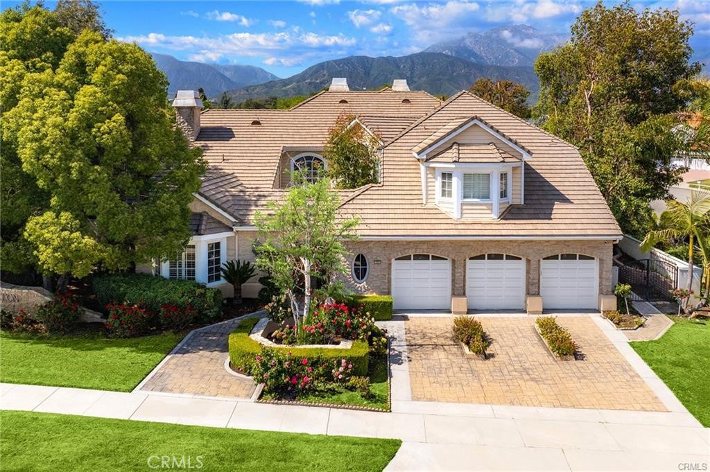 Welcome to one of the few truly custom estates in The Signature Collection, North Upland’s premier development. Designed by acclaimed Orange County builder Doyle Barker of the Jeffrey Group, this exclusive enclave of luxury homes represents the pinnacle of his work—and this particular residence was the original model, setting the standard for all that followed. From the moment you enter through the gated entry way, you are welcome by a flower garden, and step through the impressive double doors, you're greeted by soaring 20-foot ceilings and a dramatic sense of nearly six thousand square feet of interior space. Gleaming marble floors flow through much of the lower level, enhancing the grandeur of the expansive foyer, which opens seamlessly to both the formal living and dining rooms. A standout feature of this estate is the remarkable library—complete with a rolling ladder that accesses the upper shelves, ideal for displaying books or cherished collectibles. This inspiring space also functions beautifully as a home office, perfect for Zoom meetings and remote work. For the culinary enthusiast, the gourmet kitchen is a dream come true. Outfitted with gas cooktops, dual ovens, and multiple dishwashers, it offers versatility and convenience for any level of chef. A cozy breakfast nook completes the space, ideal for casual dining. The luxurious primary suite is a private retreat, featuring a romantic fireplace, built-in wet bar, and a spa-like bath with a soaking tub for two. A dedicated sauna and fitness area offer the perfect setup for your personal wellness routine—all within the comfort of your own home. Step outside to a beautifully landscaped backyard oasis, complete with a sparkling pool and spa, lots fruit trees around the property, perfect for entertaining and unwinding in total privacy. Centrally located between the 10 and 210 freeways, this home offers convenient access to top-rated schools, shopping, and all essential amenities. This is more than just a home—it’s a vacation resort style of living, and an opportunity not to be missed.