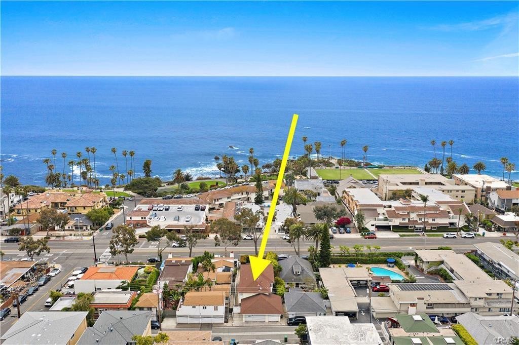 Rare opportunity in North Laguna Beach! This C-1 zoned ocean-view triplex is just one block from Heisler Park and Picnic Beach and two blocks from downtown shops, cafés, and restaurants. Nestled behind lush hedges with a large grassy front lawn and vibrant gardens, the property offers three fully updated residences -- perfect for investors, multi-generational living, or a turnkey coastal retreat. The commercial zoning allows for flexible uses, including the ability to obtain a short-term lodging permit for one of the units, enhancing income potential. Lower Front Unit (1 Bed / 1 Bath): French doors open to large grassy yard. Updated kitchen with shaker cabinets, quartz counters, and stainless appliances. Laminate floors, LED lighting, ceiling fan, plantation shutters, and mirrored closet doors. Bathroom with carrara quartz vanity and dual-head shower. Front-loading washer/dryer inside unit and private 1-car garage. Rear Studio Unit: Offered fully furnished, private back patio. Upgraded kitchen with shaker cabinets, quartz counters, stainless appliances, pantry, and coffee bar. Laminate floors, LED lighting, ceiling fan, plantation shutters. Bathroom with carrara quartz vanity and dual-head tiled shower. Front-loading washer/dryer in unit, plus parking space. Upper Penthouse (2 Bed / 2 Bath): Ocean-view deck, oversized living room, and bright, open spaces. Upgraded kitchen with white shaker cabinets, quartz counters with waterfall edge, farmhouse sink, and KitchenAid stainless appliances. Laminate floors, LED recessed lighting, plantation shutters, ceiling fans, and mirrored closet doors. Primary suite with carrara quartz vanity and spa-like tiled shower with dual heads; secondary bath with shower-over-tub. Front-loading washer/dryer in unit + private 2-car garage. The commercial zoning also opens the door to commercial financing options, giving buyers flexibility in structuring a purchase as either a residential or commercial investment. This turnkey ocean-view triplex combines prime location, modern updates, and versatile living arrangements with strong income potential. Steps to the beach, Heisler Park, and downtown Laguna Beach—an exceptional opportunity not to be missed!