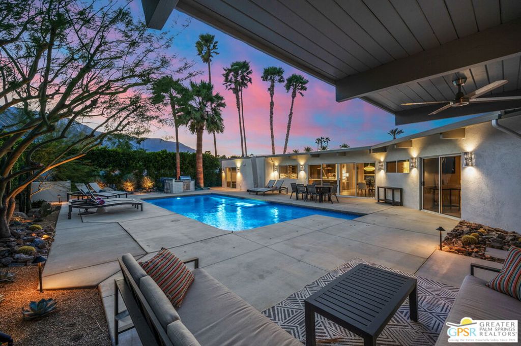Hidden behind a lush privacy hedge, this impeccably updated mid-century modern home showcases breathtaking mountain views and a perfect balance of classic design and contemporary upgrades. Light-filled living spaces, framed by walls of glass, open to the sparkling saline pool and enclosed front garden, designed by a landscape engineer and professionally executed to perfection.The heart of the home is a well-appointed kitchen centered around a large island, ideal for casual gatherings. The main house features three bedrooms, two with direct outdoor access, and two spa-like bathrooms. A new built-in BBQ with bar seating makes al fresco entertaining effortless, while the new fire pit area sets the perfect ambiance for evenings under the stars.The detached poolside casita, complete with a wet bar and breathtaking views, will make your guests swoon. Recent upgrades include a fully automated irrigation system, all-new landscape lighting on a timer, fresh exterior and interior paint and a striking burnished steel fireplace sculpture with new gas piping. Modern conveniences abound, from the hardwired Vivint security system with cameras, smart locks, and thermostat control to the electric car charger in the garage. Remote-control electric shades add comfort and privacy, while a newly added gym in the back of the garage offers a private workout space.Located in the desirable Movie Colony East neighborhood near Ruth Hardy Park, this exceptional home is just minutes from the Uptown Design District's renowned dining and shopping. Iconic architecture, modern amenities and impeccable upgrades. Offered fully furnished, this is Palm Springs living at its finest.