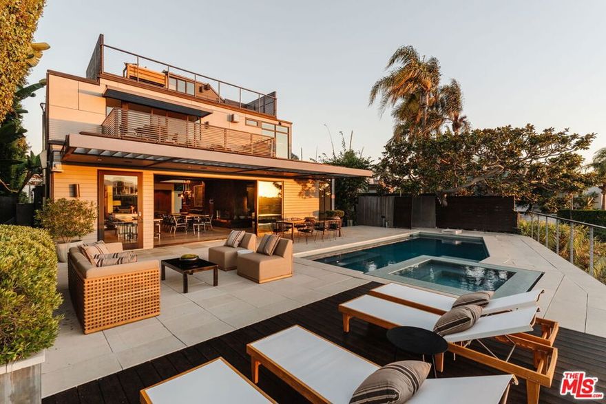 A modern architectural icon nestled in the coveted Santa Monica Canyon, 721 Adelaide Place exemplifies the visionary design of Ray Kappe, FAIA, whose renowned work defines the "apotheosis of the California House." This LEED Gold Certified residence seamlessly blends sculptural form, environmental sensitivity, and a profound connection to nature. Spanning nearly 5,000 square feet, the home is intentionally designed to celebrate volume, light, and awe-inspiring ocean, coastline, and mountain views. Upon entering, a dramatic two-story foyer sets an impressive tone. Here, a sleek floating staircase serves as a sculptural centerpiece, floor-to-ceiling glass walls allow radiant natural light to fill the space, and artisan craftsmanship is on full display with the use of wood, steel, and stone. Open-concept living and dining areas are positioned around a two-way Corten steel fireplace with a marble hearth, creating a sophisticated and inviting ambiance. The Arc Linea chef's kitchen is a showpiece of modern design and functionality, featuring a Crocodile Caesarstone backsplash, a butler's pantry, and professional-grade Wolf and Miele appliances. Retractable glass walls open the living areas to an outdoor sanctuary complete with covered and uncovered patios, a sparkling pool, an infinity-edged spa, an outdoor shower, and panoramic ocean and mountain views that elevate entertaining. Upstairs, the primary suite offers a retreat of exceptional comfort and style. Here, a private deck captures breathtaking views, while the custom-designed walk-in closet and luxurious ensuite--featuring dual vanities and an ocean-view shower--enhance daily living. Three additional bedrooms, including one on the main level, each open to private terraces, complemented by a versatile office and lower level media room. An expansive rooftop deck with a firepit crowns the home, offering a spectacular vantage for sunsets over the Pacific. Advanced smart home tech, including Control4 home automation, integrated surround sound, a Generac generator, and solar panels, ensures convenience and efficiency. Other notable features include mature landscaping that envelops the property in serenity and seclusion, a two-car garage, and automatic driveway and pedestrian gates. Supremely situated in one of Santa Monica's most desirable enclaves, this home captures the essence of California coastal living--mere moments from the beach, world-class dining and shopping along Ocean and Montana Avenues, and just minutes from the Riviera Country Club. 721 Adelaide Place stands as a testament to timeless modernism and coastal refinement, a rare architectural achievement where design and lifestyle converge.