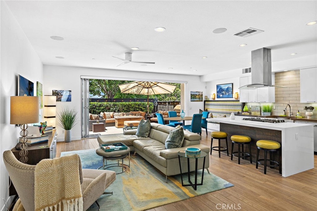 Welcome to 1289 Westreef, one of the original builder model homes, showcasing premium upgrades and modern design in one of Westside Costa Mesa’s most sought-after communities. This two-story detached residence features 3 bedrooms and 2.5 bathrooms with an open-concept layout that balances clean lines, thoughtful finishes, and flexible living. The main level offers a light-filled great room with recessed lighting, custom porcelain tile flooring, and seamless indoor-outdoor flow through La Cantina bi-fold doors. The kitchen is a true focal point, complete with quartz countertops, a large center island with bar seating, GE Café stainless steel appliances, a walk-in pantry, and sleek soft-close cabinetry. The living and dining areas connect to a private outdoor patio retreat, thoughtfully designed with built-in seating, a custom fire pit, BBQ station, and lush landscaping making it an ideal space for relaxing or entertaining. Upstairs, the spacious primary suite offers vaulted ceilings, a private balcony, a walk-in closet with custom shelving, and a spa-like en-suite bathroom with dual vanities and a glass-enclosed walk-in shower. Two additional bedrooms and a full bath complete the upper level. Additional features include surround sound throughout, a Nest thermostat, Milgard dual-pane windows, a security camera system, water softener, tankless water heater, and owned solar panels for energy-efficient living. The attached two-car garage includes built-in storage and an epoxy-finished floor. Located in Westreef, a limited collection of just 17 homes, this property offers convenient access to the Santa Ana River Trail, Talbert Regional Park, local beaches, shopping, dining, and major freeways making 1289 Westreef a rare opportunity for turnkey, contemporary living in a vibrant coastal location.