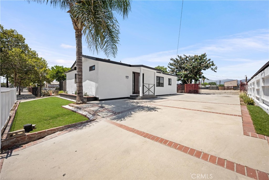REMODELED HOUSE/OFFICE + WORK YARD + 2 FRONT GATES + 2 BACK GATES — Located in the Midtown Segment of the Pomona Corridors Specific Plan, 1163 E Mission Blvd offers a rare live-and-work setup with outstanding commercial flexibility. The zoning (Pomona Corridors Specific Plan – Midtown Segment) allows a broad mix of uses by right, including office, medical, retail, artisan workshops, salons, educational services, personal care businesses, and mixed-use residential. With a Conditional Use Permit (CUP), additional high-demand uses—such as automotive services (repair, detailing, dismantling), trucking and trailer storage, towing service, impound yards, outdoor storage yards, contractor shops, light industrial or CNC machining, cannabis-related businesses, religious assembly, equipment rental, entertainment or fitness venues, drive-thru establishments, and small-scale wholesale or distribution centers—may be permitted. These uses reflect the corridor’s growing mix of commercial, industrial, and flexible-use operators. The front of the property features a fully remodeled 3-bedroom, 2-bathroom structure, ideal for professional office, medical or dental clinic, salon, or live/work residence. Recent improvements include a new roof, new windows, updated flooring, modern kitchen and bathrooms, plus upgraded plumbing and electrical — offering a turnkey space ready for immediate occupancy. Behind the structure is a large, flat open yard with full gated access from both the front and rear alley. Dual side gates and rear gates enable drive-through capability, making it perfectly suited for truck access, equipment storage, contractor operations, or outdoor workspace. The yard is built out with an additional electrical subpanel with multiple 240V and standard outlets throughout the lot, plus several water faucets and one sewer connection — delivering utility infrastructure for flexible commercial or business uses. This location, with excellent street frontage, easy access, and built-in utilities, presents an exceptional opportunity for owner-users or investors seeking a high-utility site in a busily evolving industrial corridor. Buyer to verify all zoning, permits, and development potential with the City of Pomona.