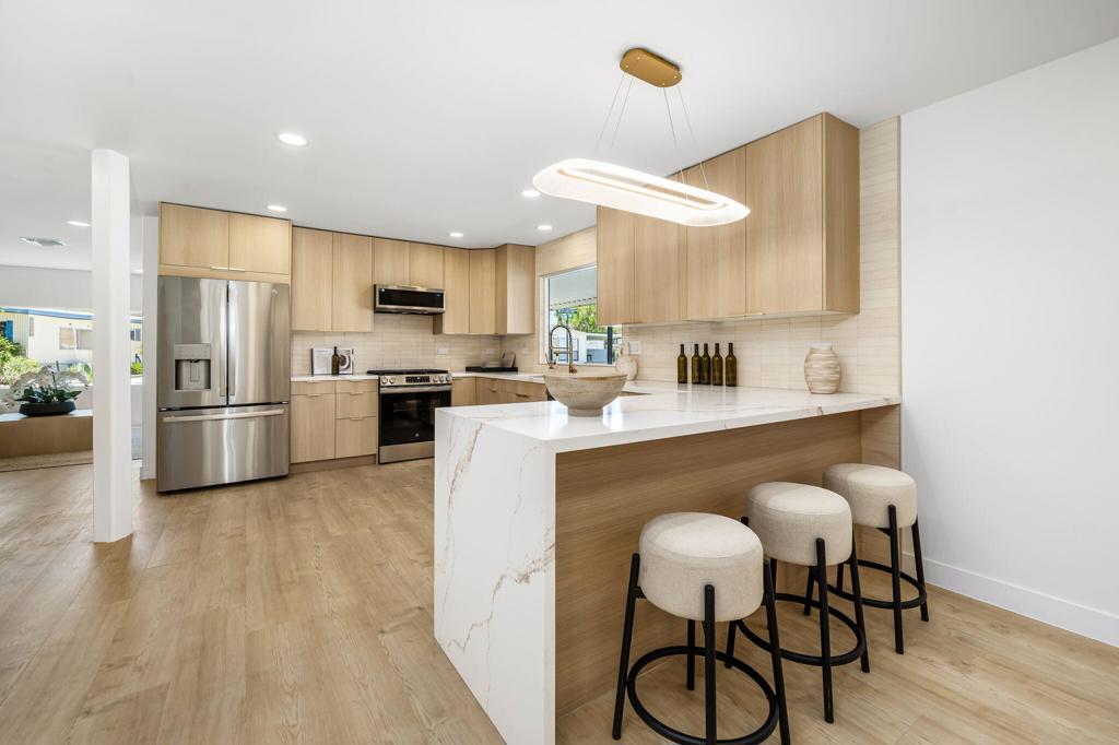 Step inside to what feels like a million-dollar home! From the level-5 smooth finish drywall to the designer tile and quartz waterfall countertops - no detail was overlooked, and no expense was spared. Fully renovated with new systems and the highest quality designer finishes. Gorgeous kitchen with new white-oak cabinets with a soft close, quartz countertops with a waterfall edge, oversized peninsula with bar seating for three, stylish limestone backsplash, and brand-new stainless-steel appliances including a 36' French door fridge and workstation sink. The designer went the extra mile with a luxurious 80'' high efficiency electric fireplace, one-of-a-kind brass fixtures, elevated aluminum and glass closet doors, and solid core steel exterior doors. Primary bedroom has a resort style feel with a large seating area and bathroom with an oversized freestanding soaking tub, walk-in shower with LED-lit niches, and a custom dual sink vanity. Fresh-modern style with recessed LED lighting and timeless white-oak LVP flooring. Brand-new central HVAC heat pump system with a 10-year warranty. Oversized carport, enclosed storage area, and a large side lot. Oversized interior corner lot. Fee land with low HOA (55+). 433a enables VA, FHA, conventional loans, and reverse mortgages for ease of financing. Ground level, no interior or exterior steps, and curb-less walk-in primary shower. Enjoy two 18-hole golf courses, multiple swimming pools, hot tubs, tennis courts, shuffleboard, pickle ball, putting green, billiard room, clubhouse and a bar/restaurant. Major stores like Costco and Walmart are just up the street. Amazing Hiking and Natural Oasis nearby at Thousand Palms Oasis Preserve. Close proximity to the $300 million, 11,000 seat Acrisure Arena: home of the Coachella Valley Firebirds hockey team. Acrisure Arena is major attraction hosting concerts, sporting events and more totaling 120+ events annually. You've seen all the other sleepy homes on the market. Now is your chance to live bold! This home will make you the envy of your neighbors and a favorite party host!