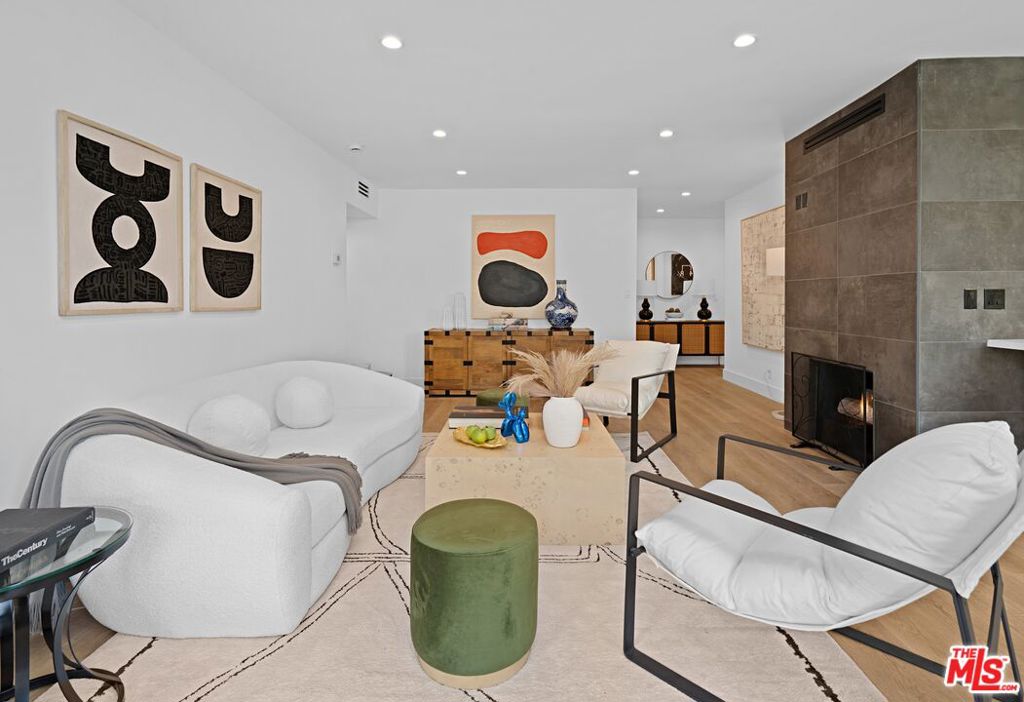 Never lived in after its full remodel, this bright and spacious 2-bedroom, 2.5-bath condo blends modern design with comfort and ease. The airy interiors feature all brand new appliances, custom cabinetry, sleek finishes, smart climate control, a gas fireplace, and in-unit washer/dryer. Enjoy treetop views from both bedrooms, the living room, and kitchen - the perfect backdrop for morning coffee on the balcony. Just two buildings from Gelson's and only moments to celebrated fine dining and West Hollywood's vibrant nightlife, this location is as dynamic as it gets. Yet once you're home, the atmosphere is quiet, peaceful, and surrounded by greenery - with Kings Park next door for dog walks, a playground, and free Saturday theater. Practical comforts include two gated side-by-side parking spaces, designated guest parking in front, and a large storage unit. Low HOA dues provide resort-style amenities: gym, pool, spa, and sun deck. At day's end, unwind on the rooftop deck with a glass of wine, taking in sweeping views from Century City to Downtown Los Angeles. Unlike any cookie-cutter condo, this residence is a truly rare find - stylish, serene, spacious, and secure. A sanctuary in West Hollywood, ready to welcome its next owner. Come see this chic, cozy haven and reimagine the possibilities to make this your dream home!
