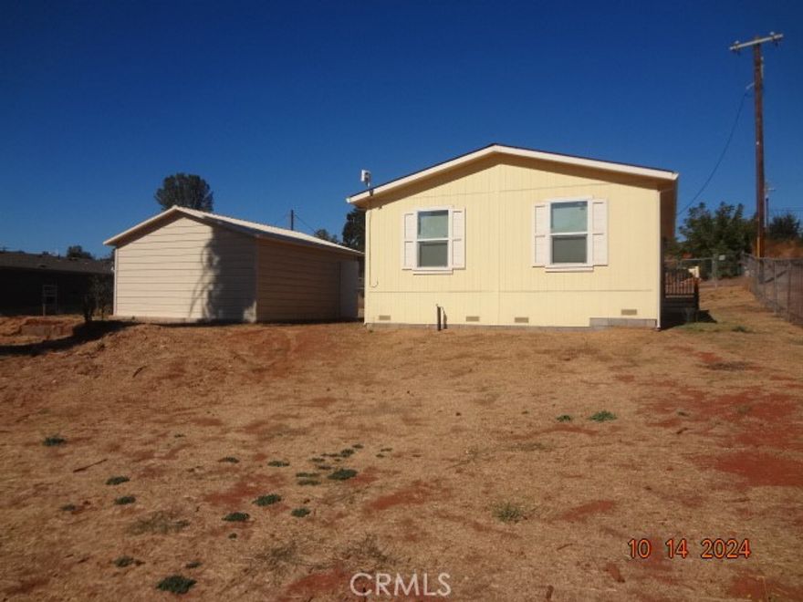 Here's your chance to live on the water.  Records show this Cache Creek front manufactured home as a 24 ft x 40 ft with 3 bedrooms 2 baths and detached double garage.  Home was installed in 2023.  Living Room is open to the kitchen/dining area; kitchen has stainless electric stove, microwave hood, dishwasher and adjoining separate laundry room with exterior door to the side.  Living room and bedrooms are carpeted; main bedroom has walk in closet.  Main bath has tub/shower combination.  Hall bath also has tub/shower combination. Nice sized double detached garage; lot is fenced.