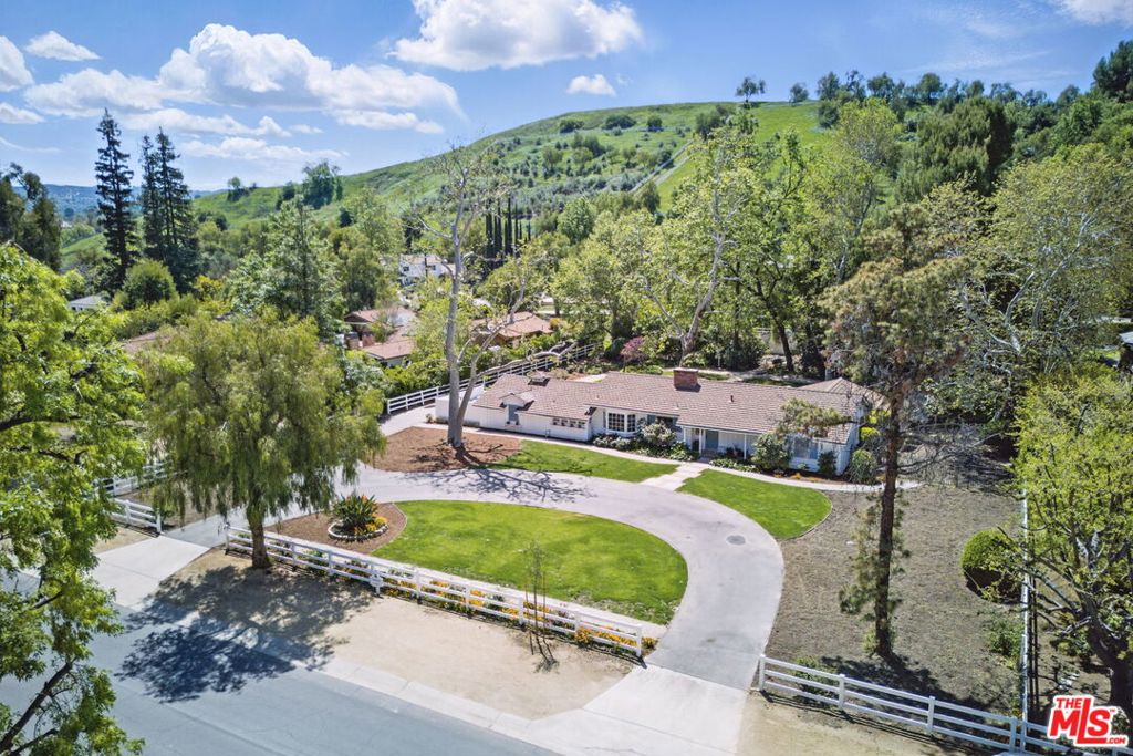 An incredible opportunity and unique chance to own a piece of Hidden Hills history with a graciously maintained property, prime location, and potential to create your own legacy in one of the most coveted communities awaits. First time on market, this iconic ranch home sits on a magnificent flat 1+ acres lot in the prestigious guard-gated community of Hidden Hills. Built in 1951 and cherished by the same family for over seven decades, this expansive property has a prime location on Long Valley Road, combining privacy with accessibility, adorned with majestic trees and an impressive rose garden that showcase the property's rich heritage. Beyond its current charm, the property's pristine condition allows for a turnkey opportunity, a thoughtful renovation of the existing ranch home or seize the opportunity for an exceptional development option to reimagine the site in one of the most exclusive communities. With 35 miles of winding horse and hiking trails, riding arenas, tennis and basketball courts, and a community center that hosts theater groups and social events throughout the year, this unique neighborhood offers a serene countryside feel while being just minutes from upscale boutique shopping, fine dining, and the award-winning Las Virgenes School District.