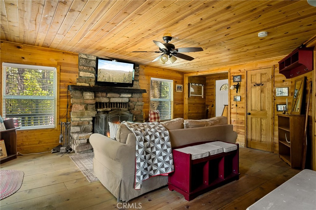 Just a stones throw from Green Valley Lake and local shops, this storybook cabin has not only stood the test of time—it’s emerged stronger, cozier, and more charming than ever. Lovingly reimagined, with upgraded plumbing and electrical, newer kitchen, bathroom and exterior paint plus warm tongue-and-groove woodwork from floor to ceiling.
In 2023, this magical cabin received a brand-new roof and a powerful whole-house generator (available at an additional cost), ensuring it stays comfortable no matter what weather drifts in. The original stone fireplace anchors the living room with timeless charm and a crackling welcome. Double-paned windows, a tankless water heater, and inside washer/dryer setup add comfort and practicality, while the upgraded panel is ready to power future dreams: EV charger? Hot tub? You're ready!
Out front, there’s a hidden gem: a fully insulated shed perfect for guests, storage or creative projects. Beneath the deck, keep your kayaks and snow gear out of the way for the off-season, but always within reach.
Located on a peaceful street beside a vacant double lot (with a friendly potential seller!), this cabin is 100% move-in ready—just waiting for the next chapter in it's mountain tale.