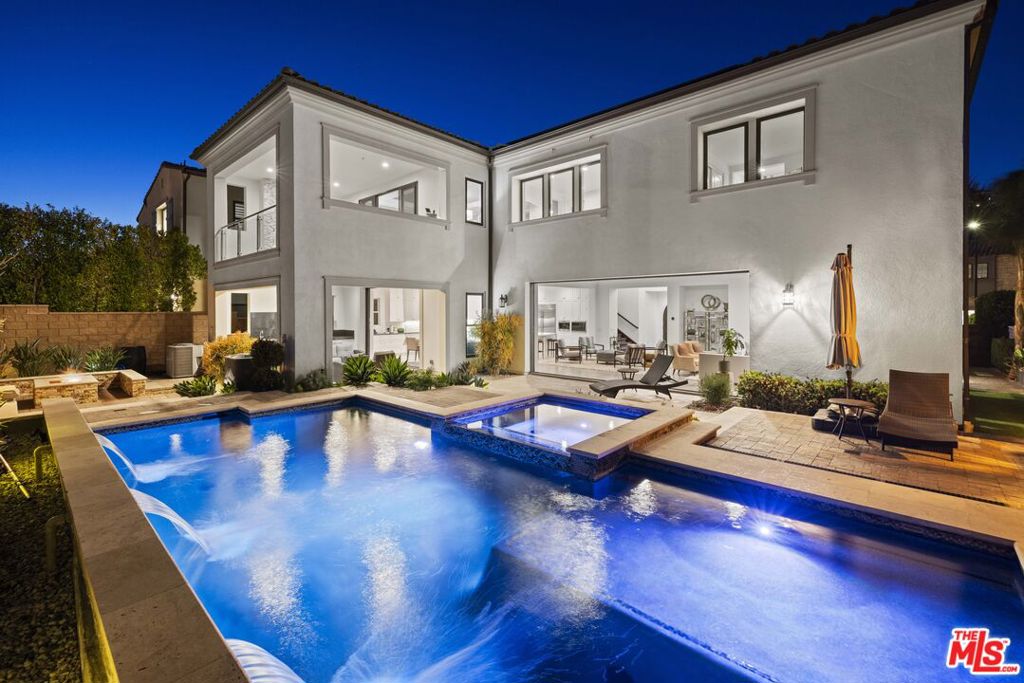 Experience contemporary luxury and breathtaking city and valley views at 20162 W Cromwell Way, a beautifully upgraded Toll Brothers Cahill residence located in the prestigious, guard-gated Westcliffe at Porter Ranch. With over 5,000 square feet of elegant living space, this 5-bedroom, 5.5-bathroom home offers refined design, seamless indoor-outdoor living, and resort-style amenities. The grand foyer opens to a light-filled, open-concept layout featuring a spacious great room and formal dining area, seamlessly extending to the lush backyard through a 20'x9' pocket sliding door that disappears into the walls. The gourmet kitchen is a culinary dream, showcasing dual waterfall islands, WOLF appliances including a built-in coffee system, SubZero refrigerator, BOSCH dishwasher, custom cabinetry, and a large walk-in pantry. An additional sliding door opens to a stylish outdoor lounge complete with a full kitchen perfect for entertaining in true California fashion. Upstairs, a flexible bonus room provides space for a media room, office, or playroom. The expansive primary suite features a private balcony with fireplace, sweeping views, and a spa-inspired bath with a freestanding tub, oversized walk-in shower, dual vanities, and a generous walk-in closet. The private backyard oasis includes a sparkling pool and spa, spacious patio, and panoramic vistas. A main-level guest suite offers ideal accommodations for visitors. Additional highlights include an EV charger, a fully paid solar system with 45 panels delivering nearly zero electric bills, a two-car garage plus separate one-car garage and proximity to top-rated schools such as Sierra Canyon, PRCS, Heritage Christian and more. Conveniently walk to Whole Foods, Ralphs, restaurants, yoga studios, Pilates, AMC Theaters and more with nearby access to Porter Valley Country Club for golf. This exceptional home captures the best of upscale living in one of Porter Ranch's most sought-after communities. Schedule your private showing today.