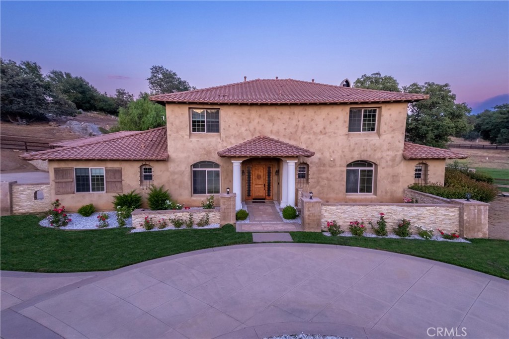 Live in La Cresta’s only gated community – Meadow Oaks, where security, elegance, and usable acreage converge. This 4,784 sq ft estate sits on 4.77 flat, buildable acres surrounded by ancient oaks and tranquil country views. Ideal for equestrian use, multi-generational living, or high-end retreat development.
This expansive 6-bedroom, 4.5-bathroom home features multiple oversized living spaces, including a massive main-level family room, formal living room, formal dining room, and a bonus upstairs family room — perfect for large gatherings or flexible living needs. The primary suite is located downstairs and features a fully remodeled spa-style bathroom, walk-in closet, and private views of the surrounding landscape. Vaulted ceilings, brand new stone flooring throughout, and new carpet in the bedrooms deliver a modern, upscale feel.
The property offers multiple flat buildable pads for a future barn, guest house, or ADU. There’s room for horses, trailers, and RVs, all tucked behind a gated circular driveway and a true 5-car garage with oversized bays and parking for 10+ vehicles.
A well permit has already been secured, and a drilling site has been identified — providing optional private water access for future agricultural, equestrian, or sustainability goals.
Located just minutes from the Santa Rosa Plateau Reserve and miles of riding/hiking trails, Meadow Oaks is known for its privacy, low HOA, and rural charm — all within an hour of Orange County and minutes from Temecula Wine Country.
Usable land. Expandable footprint. Private water permit in place. Timeless design with room to grow.