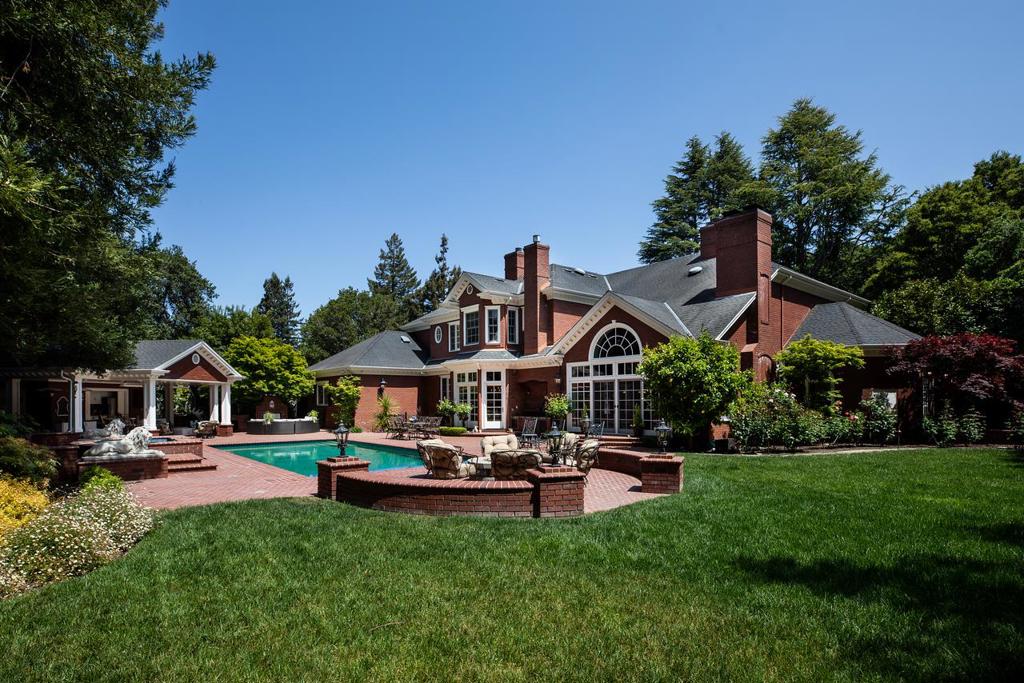Masterfully built classic colonial estate in prime Lindenwood neighborhood. Reminiscent of "Home Alone" architecture, this 3-level home features a stately brick facade, refined millwork, custom cabinetry, and richly hued solid hardwood floors. A dramatic 2-story foyer with floating staircase spanning three levels leads to elegant formal rooms, a mahogany library, and a formal dining room with butlers pantry and living room with fireplace. The chefs kitchen boasts Rutt cabinetry, granite counters, two pantries, and top of the line appliances, opens to a large breakfast room and all overlooking the rear yard. The family room has soaring ceilings, impressive fireplace, media cabinetry, and pub-style bar. Main floor bedroom suite and laundry/mud room complete the main level.Upstairs is the luxurious primary suite with sitting room, fireplace, couture closet, and marble bath. Three additional and generously sized bedrooms on the upper level. Lower level offers a rec room with bar, 2,800-bottle wine cellar, gym with steam shower/sauna, and pool-table room with bar. Resort-like yard with pool, spa, fire pit, sport court, playground, batting cage, full kitchen in cabana with changing room and bath. Home automation, generator, top Menlo Park schools-a rare find of undeniable quality.