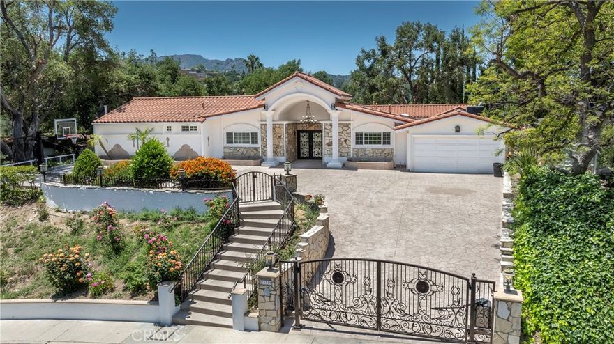 This exquisite single-story Spanish estate blends timeless elegance with modern sophistication. Set back from the street behind a private gate, the home welcomes you with a dramatic double-door entry that sets the tone for the refined interiors beyond. Inside, classic arched doorways, artisanal tile floors, and expansive walls of glass create a luminous ambiance, framing picturesque views of the lush backyard sanctuary and a serene courtyard. Three spacious bedrooms and three well-appointed baths and a versatile den offers the perfect option for a fourth bedroom, home office, or creative space. Designed for effortless living and entertaining, the generous common areas include a refined dining room with a built-in wine fridge, a warm and inviting family room centered around a statement fireplace, and an impressive wet bar ideal for hosting. The gourmet chef’s kitchen is a true showpiece, featuring an oversized stone island, custom cabinetry, and top-tier appliances, including Bosch and Sub-Zero, complemented by a six-burner cooktop and dual convection ovens. The luxurious primary suite serves as a private retreat, complete with French doors that open to the resort-style backyard and a spa-inspired bathroom offering a jetted soaking tub, walk-in shower with seating, and dual bowl basins. Outdoor living reaches new heights with beautifully landscaped grounds enhanced by glass-paneled fencing that showcases verdant vistas and distant mountain views. Enjoy unforgettable gatherings with a built-in BBQ and pergola, seamless indoor-outdoor dining through expansive sliders, and a sparkling pool and spa surrounded by stone accents and swaying palms. A rare opportunity to live in one of the Valley’s most sought-after enclaves south of Ventura Boulevard within the coveted Lanai School District and close to all of the fine restaurants and upscale shopping along Ventura Blvd, while providing easy access to the Westside.