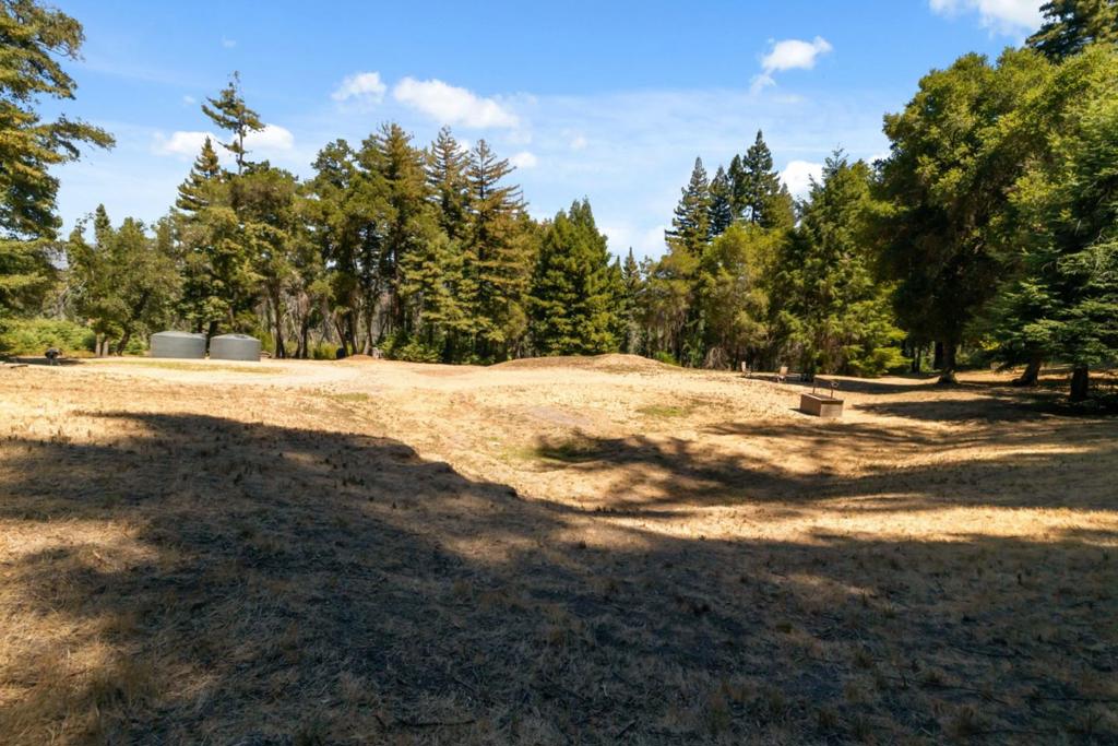 A rare blend of sunshine, serenity, and usable land awaits at this 4.39-acre retreat with end-of-the-road privacy and sweeping views across the San Lorenzo Valley. Surrounded by towering redwoods and bordered by expansive undeveloped land, this property feels even more private and secluded than its acreage suggests. Formerly home to a 2-bed, 2-bath residence, lost in the CZU fire, the site is ready for your vision. County-approved rebuild plans, soils report, and copies of the previous design are included to fast-track your project. Utilities are already in place, including PG&E service with a 200-amp panel plus a 70-amp/220 outlet for a welder. A working septic system and private well (producing 810 GPM at last check) add to the convenience. The standout feature is the surviving 800 sq. ft. steel shop a 20x40 structure with 14-foot ceilings, full insulation, a monolithic slab foundation, and epoxy-sealed concrete. Perfect for storage, hobbies, or as a construction base while you rebuild. Zoned Special Use (SU), the land offers flexibility for a variety of purposes. With sun-drenched clearings, shady groves, and level ground, the possibilities are endless. Here, youre not just buying acreage youre claiming a private slice of the valley with the hard work already started.