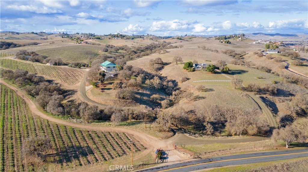 Nestled within the rolling hills of Paso Robles, 390 San Marcos Road is a stunning 64+/- acre vineyard estate featuring two residences. Both homes are currently licensed and operating as vacation rentals. The primary residence is a 2,700+/- sq. ft. ranch-style home, offering 3 bedrooms and 3 bathrooms. A spacious wraparound porch invites guests to take in panoramic views of the vineyard and surrounding countryside. The second home, located at 380 San Marcos Road, is a charming 1,900+/- sq. ft. property with 3 bedrooms and 2.5 bathrooms. It also boasts a private, covered porch—an idyllic spot to enjoy Paso Robles' breathtaking summer evenings. The estate includes an established 10+ acre vineyard planted with Cabernet and Syrah vines, which gracefully weaves through the property. Additionally, a 2,000 sq. ft. metal shop supports the vineyard's day-to-day operations. With ample remaining acreage, there is plenty of space for equestrian enthusiasts to build a barn or arena. Whether you're an investor seeking a profitable income property or looking for a multi-generational family estate, June Vineyard offers a solid foundation for the next owner to make this beautiful property their own.