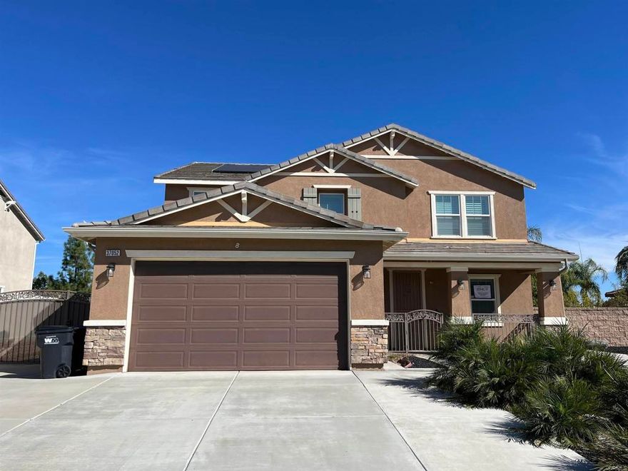 Beautiful 5 bedroom home located within a very desirable neighborhood. This lovely home features custom "wood" ceramic tile floor throughout the 1st level, plantation shutters, recessed lighting, formal living room, family room open to kitchen, dining area, and lots of windows allowing for abundant natural light. The kitchen features open concept to family room, lots of counter space and cabinets for storage. 1st level bedroom and bathroom, laundry room, and sliding door leading to the fully covered patio. The 2nd level features a loft, four bedrooms with ceiling fans, lots of windows, and wall to wall carpet. Master bedroom with double entry doors, great views from all the windows, walk-in closets, master bath with dual sinks, bathtub, and separate shower. The 3 car tandem garage features storage cabinets, tankless water heater, and side entry door. This home comes with Solar Panels which are paid for. RV parking potential with concrete parking already in place, large back yard with children's play set, trampoline, storage shed, and side yard with several fruit trees! The wonderful covered patio is huge and features 2 ceiling fans, rain gutters  Don’t miss the opportunity to own this well-maintained gem. This is more than just a house—it's the place you’ll want to call home.
