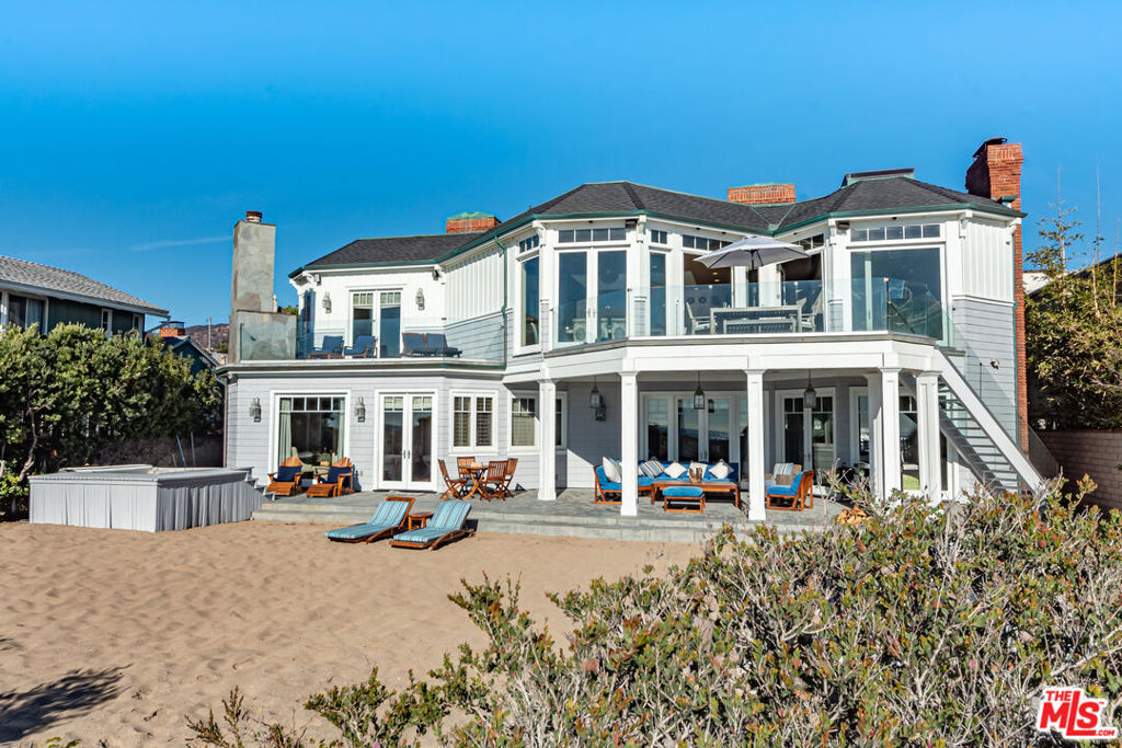 Situated on a rare 80-foot beachfront lot on Malibu's exclusive Broad Beach, this Cape Cod-style estate offers expansive ocean views and seamless indoor-outdoor living. The main residence features six bedrooms plus an office, with soaring 20-foot open-beamed ceilings, abundant natural light from skylights throughout and ocean views from most rooms. The kitchen is the centerpiece of the home, flowing into the family and dining rooms and opens to a large private ocean-view deck. The kitchen is outfitted with granite countertops, Viking appliances, three ovens, two dishwashers, and generous custom cabinetry ideal for entertaining or catering large gatherings. The house boasts two primary suites, one on each level. The main level suite includes a private oceanfront deck with an outdoor fireplace. The grand primary suite offers two custom walk-in closets and two bathrooms, one of which features a spa-like ambiance with a steam shower and a stand-alone soaking tub. Other bedrooms in the main house include an ensuite that opens to a grassy courtyard, a bedroom that opens to the beach and a full ensuite bedroom great for guests or staff. Additional amenities include a private sauna, outdoor spa, and large detached guesthouse with a full kitchen, bedroom, and 1.5 bathrooms perfect for guests and extended stays. The property also features an outdoor shower, a three-car garage, and easy access to Trancas Country Market, just a short walk away, offering dining, shopping, and more.
