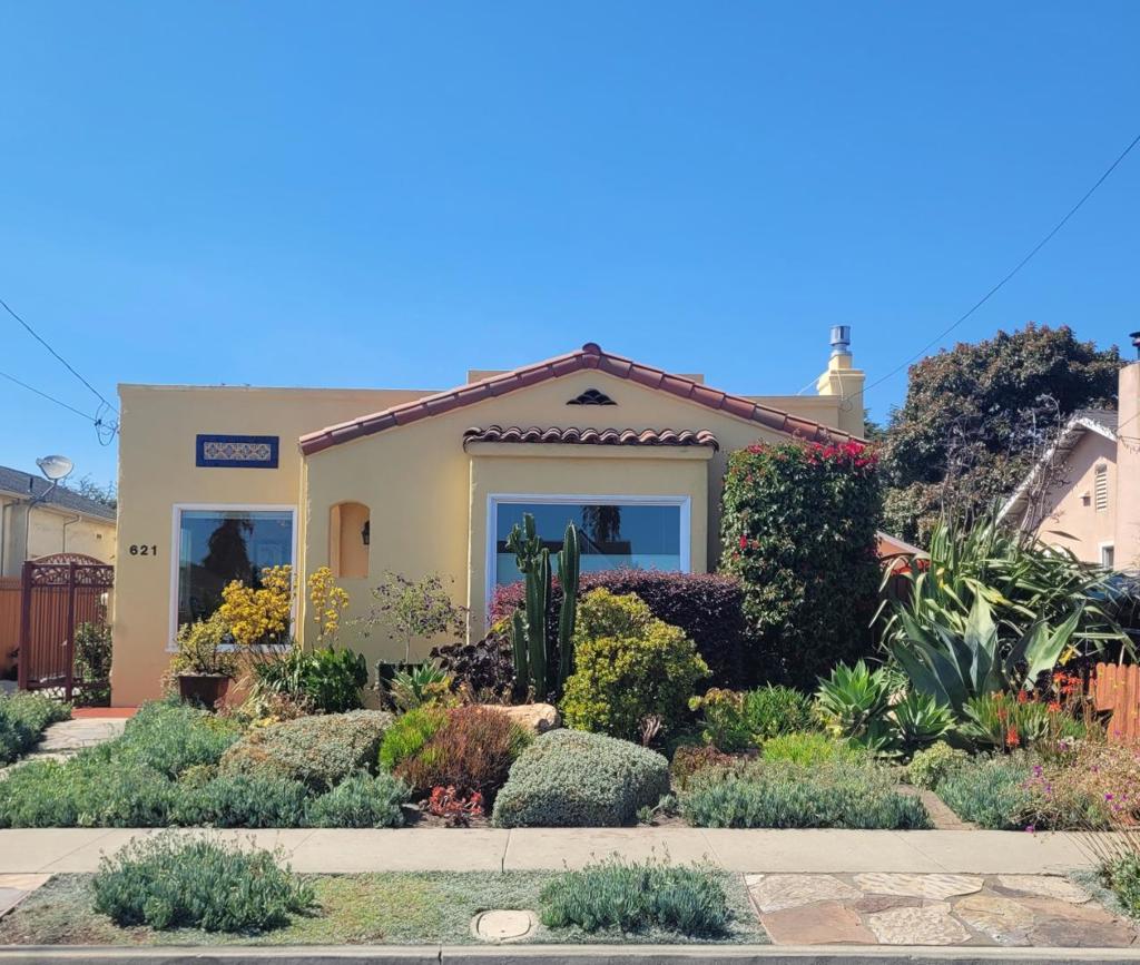 This lovingly maintained Spanish style home has beautiful drought tolerant mature plantings in the front yard, as well as a watering system. The permitted ADU of 320 sf has tons of natural light and views of the garden, behind the 360 sf two car garage. The ADU has a galley kitchen and area perfect for a small dining table and there is a wall of built in storage. A custom mechanized gate and matching side gate create a finished look with major curb appeal. There is room for two cars behind the gate in the driveway. In the fully fenced backyard, there is a balance of artificial grass, raised garden beds, a dwarf avocado tree and a concrete patio area for lounging and entertaining. The home has lovely details including hardwood floors, and double pane windows that let the sunshine into every room. Interior arched doorways add charm. A gas fireplace and mantle niche create a cozy focal point in the living room. Both full bathrooms have been remodeled with chic black and white tile and timeless fixtures. The home and the ADU each have on demand water heaters. 621 Oregon Street is a perfect multigenerational home or primary home with rental income opportunity.
