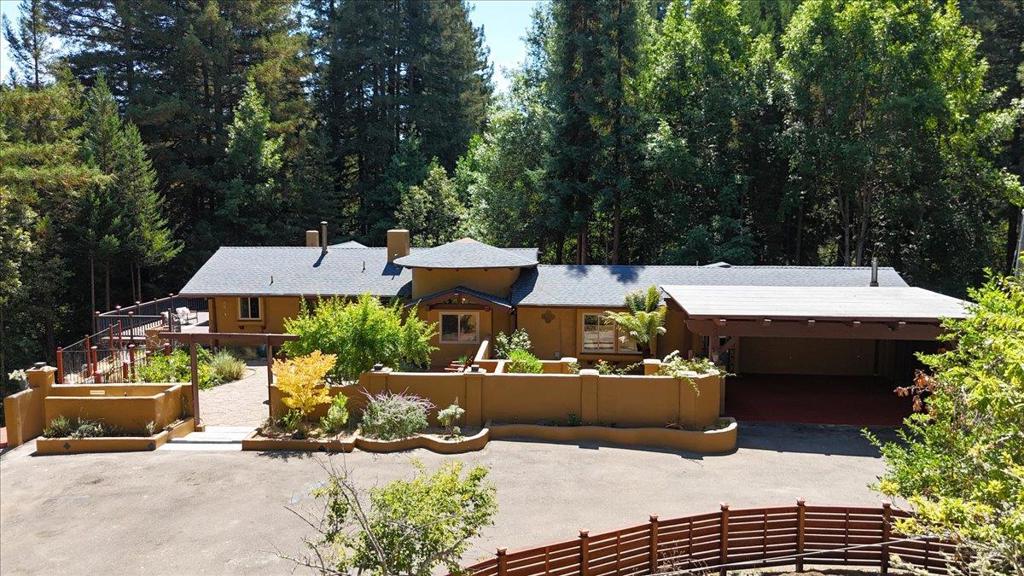 This unique property exudes peace & tranquility, offering versatile living spaces & enchanting outdoor areas designed for relaxation & connection. The main home features 2 bds, 2 ba, plus a bonus room that could serve as a library, home office, or even an additional bedroom. Attached is a permitted ADU including its own private entrance, a lovely courtyard, & back deck, making it perfect for guests, extended family, or rental income. Enjoy it as a 2-bd, 2-ba home w/ a bonus room & an ADU - Or as a 3-bedroom, 3-bath retreat, with a bonus room. The open-concept layout seamlessly connects the kitchen, dining, & living areas, anchored by an oversized stone fireplace. The primary suite is its own sanctuary, complete with a wood-burning fireplace, & a spa-like bathroom featuring a Jacuzzi tub set before a bay window with tranquil forest views. The outdoor spaces are where this property truly shines. A large wraparound deck invites you to soak in the surrounding nature, while the welcoming courtyards, cozy conversation pits, & 2 outdoor showers, create magical spaces to gather & unwind. Plenty of parking, offering a large carport area & room for an oversized vehicle. Whether you're looking for a peaceful getaway or a versatile home with income potential, this gem is a must-see.