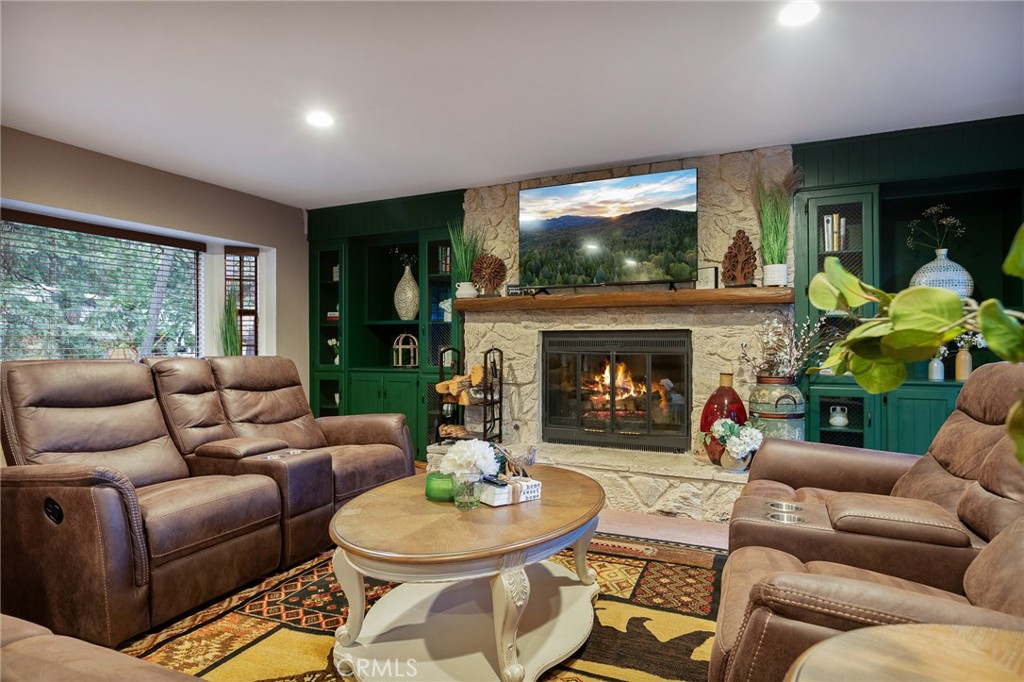 WOW, WOW, WOW!!! Looking for a Super Cool RUSTIC CABIN with a GREAT MOUNTAIN VIBE to Escape to? YOU WILL ABSOLUTELY LOVE this One with it's A-Frame Windows, Woodburning Stove and Cutesy Mountain Touches Throughout! You Won't Feel Cramped Here with Five Bedrooms Generously Spaced Apart, including an En Suite Bedroom on the Main Level! The Oversized Family Room is Sooo Dreamy with a Cozy Wood Burning Fireplace and HUGE WINDOWS Everywhere to Watch the Snow Fall! Did I mention Snow? Just a 10 Minute Drive to Snow Valley Ski Resort (Woot, woot!) and 15 Minutes to the Lake Arrowhead Village! The Island Kitchen with Breakfast Bar for the Kiddos has Oodles of Storage Space & Looks out to the Wall of Windows that Opens to the Amazing Back Deck Area! The Decking Runs the Length of the House and Has Multiple Sitting Areas that Overlook the Forest. PERFECT FOR ENTERTAINING!!! So Peaceful and Serene!!!! The 5th Bedroom Has a Separate Entrance Down Below. Recently this Home Has Been a Very Successful Air Bnb, Bringing in Approx $500/night!! Totally Level Entry into this Home too and a Big Backyard Makes this a Perfect Full time Home too! Come & See!!