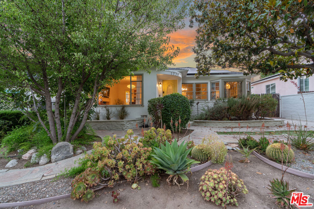 Stunning 1941 Traditional with views of the towering San Gabriel Mountains, in the much-coveted President Streets neighborhood near the Nature Preserve. Featuring a main house consisting of 4 bedrooms and 3 bathrooms, plus a detached guest house (measured at 592 square feet), which includes a full bathroom, a second laundry hookup, storage area, and a soundproof music room. Past the lush and drought-tolerant greenery and the meandering stone walkways, you will find the inviting living room, anchored by a fireplace, with an oversized picture window that brings the outdoors in. Warm original oak floors lead you into the formal dining room via a large archway, where you can enjoy your meals with views out to the garden, where details like the home's original porthole window and curvature of the front porch remind you of a time when all the details of a home were carefully crafted and thought out. The modernized kitchen immediately draws your eye to the quaint breakfast nook, with bay windows and original wainscoting. Other unique details include beamed ceilings, fun saloon doors leading to the laundry room, and a scalloped valance above the sink. Light-filled and airy, with glass-front cabinets, quartz countertops, and brass hardware- the kitchen is a seamless blend of classic and modern. French doors lead you to your own Mad Men-style office, with rich wood built-ins, a sink for a wet bar, and an arched transom window. Bathed in light with an oversized skylight and its own en-suite bath is one of the bedrooms. Off the long hallway, you will find a full bathroom featuring classic black-and-white tile and dual windows. Another large bedroom, with a door leading to the beautifully lit backyard, and the primary suite make up the rest of the main house. The primary suite is 560 square feet of sheer delight, featuring a vaulted ceiling, a skylight, two closets, bay windows that include French doors, and a stunning bathroom with an oversized shower and built-in bench and shelf, dual sinks, and a closet with new custom-built storage shelving and pocket door. Completely gut-renovated in 2024, with bold and brilliant porcelain olive green tile from Wow Design EU and Huntington White Terrazzo floors. Step outside and stare in awe at the grandeur of the towering mountains from your hammock while eating an orange from your abundantly producing tree. The flagstone path leads you to the recently gut-renovated guest house, and it is absolutely incredible. Telescoping Fleetwood sliding glass doors lead you to a foyer with oak built-ins and a sink with a refrigerator. The main area showcases vaulted ceilings, a skylight, custom casework shelving with integrated lighting, and hardwired internet. Polished concrete throughout, and new Milgard windows, plus a well-sized bathroom with oversized shower, vertical picture window, floating vanity, and dazzling olive porcelain tilework. Need a space to make some noise? This guesthouse also features an interior room with soundproofing materials between double drywall and mounted picture lights to showcase your favorite art pieces. A storage area with laundry hookups and a utility sink finishes off the space. The property also features an owned solar system, seamless gutters (2024), an EV charger (2024), 200-amp upgraded panel, 30-year roof replaced in 2017, retrofitted foundation (2024), and a new water main line (2024). Minutes to Old Town Pasadena with its renowned shopping and dining, and other close treasures such as the storied 'Christmas Tree Lane,' with over 100 cedar trees lit up during the holiday season; this neighborhood has a unique blend of old charm, small-town vibes, and unmatched natural beauty in Los Angeles.
