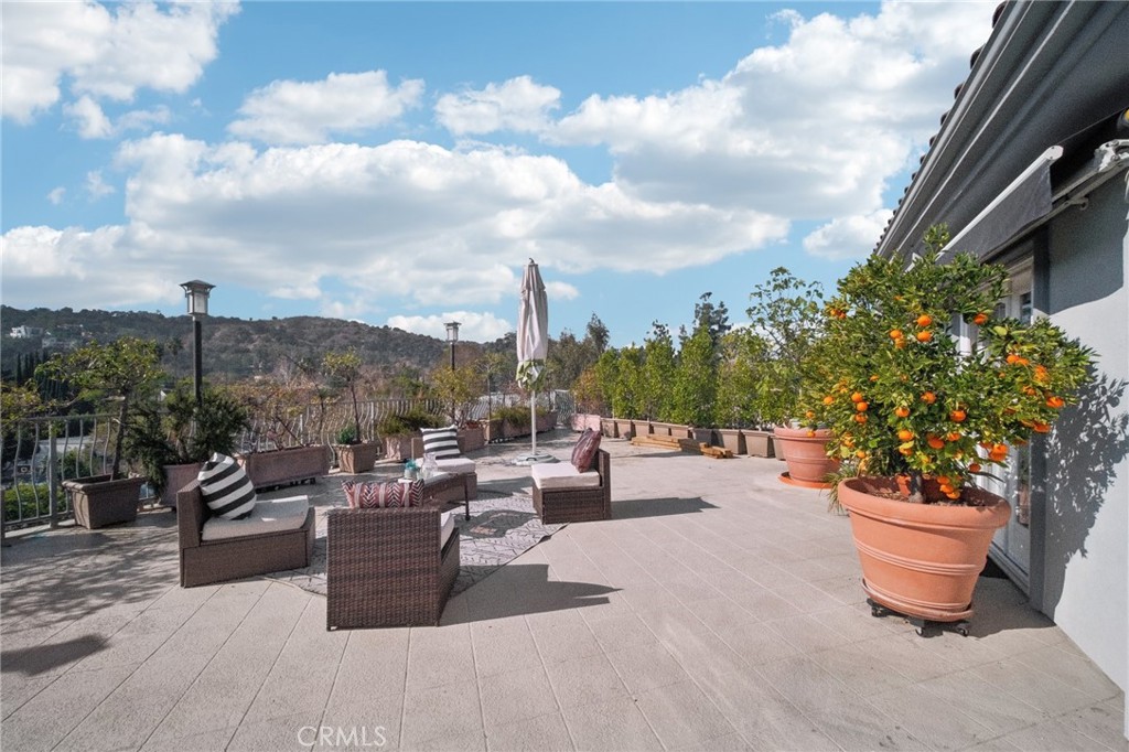 Proudly introducing this stunning 3-bedroom, 2.5-bathroom, 1,783 sq. ft. townhome-style condo located south of the Boulevard in the highly desirable Laurelwood Terrace community. This contemporary two-story gem boasts an expansive 1200 sq. ft. PRIVATE TERRACE DECK with breathtaking views of the Studio City hills, complete with rooftop patio outdoor BBQ island station, mini fridge, 2 retractable awnings, TV, and lighting—perfect for entertaining or relaxing under the California sun. Inside, you'll find three spacious bedrooms with newly installed flooring and each with their own french doors leading to the amazing terrace! A luxurious primary suite featuring a walk-in closet, a spa-like bathroom with a large soaking tub, granite finishes, travertine flooring, and a separate glass-enclosed shower. The galley style kitchen boasts stainless steel Bosch appliances, a breakfast nook, and a convenient built-in workstation. Spacious living room seamlessly blends into the dining room with great convenience! Unit has no neighbors above or below for extra privacy! Other great features include newer AC units, freshly painted throughout, added crown molding, recessed lighting, new light fixtures throughout, in-unit laundry for convenience, a water softener system and two side-by-side parking spaces, plus three guest parking spots. Community amenities include a sauna, weight room, unit's own large storage room and HOA services covering trash, water, building maintenance, and insurance. Located within walking distance of the shops and restaurants on Ventura Boulevard, this home is in the prestigious Carpenter Elementary School with a great school district. It’s also close to Radford Studio Center, where exciting redevelopment plans promise to boost the area's economic growth and property values!