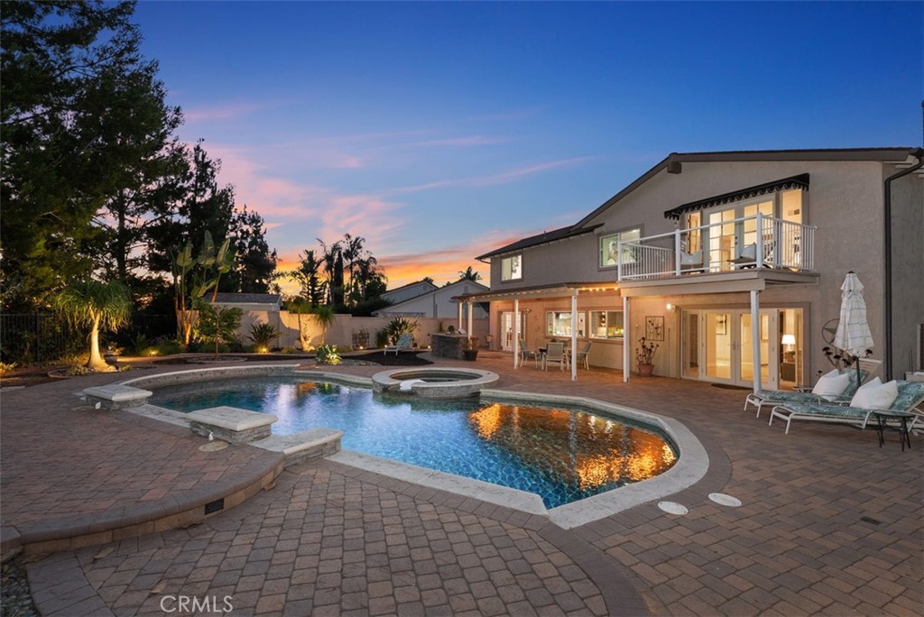Welcome to 26872 La Sierra Drive, a beautifully upgraded home in the heart of South Mission Viejo designed for effortless indoor/outdoor entertaining and relaxed California living. This spacious 5-bedroom, 2.5-bathroom home (with potential for a downstairs bedroom and full bath conversion) sits on a rare 9,750 sq ft flat lot and features an entertainer’s dream backyard that feels like your own private resort. From the moment you arrive, the home impresses with a paver-lined driveway, courtyard, and backyard patio. Enter through custom glass double doors into a grand foyer with soaring ceilings and a sweeping staircase. The formal living room features a cozy fireplace and flows seamlessly into the dining room, where French doors invite you outside to the stunning backyard. The chef’s kitchen is the heart of the home, boasting sleek European cabinetry, gas cooktop, double ovens, built-in prep area, breakfast nook, and a wall of windows showcasing the backyard oasis. The kitchen opens to the expanded family room with fireplace and French doors leading outside. This area includes space that can easily be converted back to a downstairs bedroom or office. A large powder room nearby offers the flexibility to add a full bath—ideal for guests or multi-generational living. Upstairs, the primary suite is a true retreat, complete with French doors to a private balcony with views of the backyard and evening sunsets. The en-suite bath includes dual closets, walk-in shower, and private water closet. Four additional bedrooms and a full bath complete the second floor. Outside, enjoy a saltwater pebble-tech pool & spa with waterfalls, built-in BBQ with storage and fridge, firepit, covered patio, and multiple seating areas—all surrounded by lush, drought-tolerant landscaping and LED lighting. The location is unbeatable! Just steps from the Sierra Recreation Center—with membership options for the pool, spa, water slide, fitness center, and more—this home also offers easy access to Granada Park and a variety of neighborhood schools. Enjoy Lake Mission Viejo, where you can swim, BBQ, fish, or rent boats and paddleboards. Conveniently situated near Mission Viejo Country Club, shopping, dining, the 5 Freeway and both 73 and 241 toll roads, this home is also just a 10–15 minute drive from world-class destinations like Laguna Beach, Dana Point Harbor, and more! This is California living at its finest.