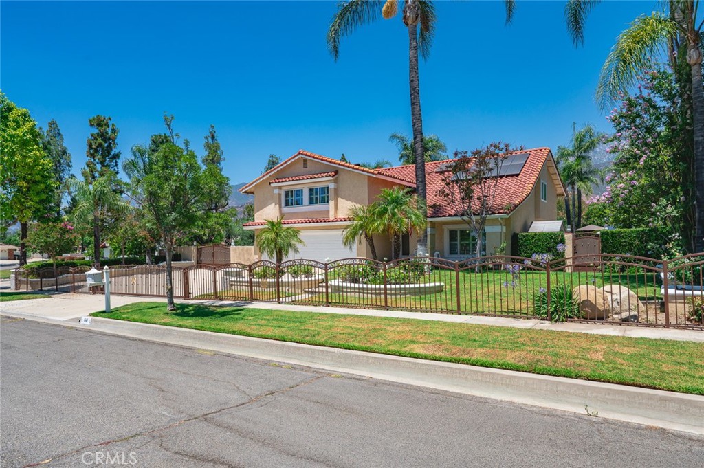 Beautiful Spanish-style home located in a desirable Upland neighborhood, featuring 4 bedrooms plus a large bonus room (potential 5th bedroom), 2.5 bathrooms, and over 3,000 sq ft of living space on an expansive nearly 20,000 sq ft lot. This upgraded home offers formal living and dining rooms with cathedral ceilings, wood floors, wood shutters, and a stained glass front door. The open-concept kitchen includes granite countertops, custom cabinets, stainless steel appliances, and travertine flooring that extends through the kitchen, family room, entry, and guest bath. The cozy family room features a fireplace and built-in bar. Upstairs boasts upgraded Pergo flooring and granite in all bathrooms. The resort-style backyard showcases a large pool with three waterfalls, a sunken spa, A sports court, RV parking, and an outdoor kitchen with BBQ, fridge, sink, two burners, stainless steel drawers, and an ice bin. Enjoy three aluminum patio covers, lush landscaping, and a variety of mature fruit trees including avocado, orange, lemon, lime, and apple. Additional highlights include a new A/C unit, dual-pane windows, indoor laundry with sink, gated driveway, fully paid SOLAR system, Spanish tile roof, and a three-car garage with two automatic openers. Priced to sell!