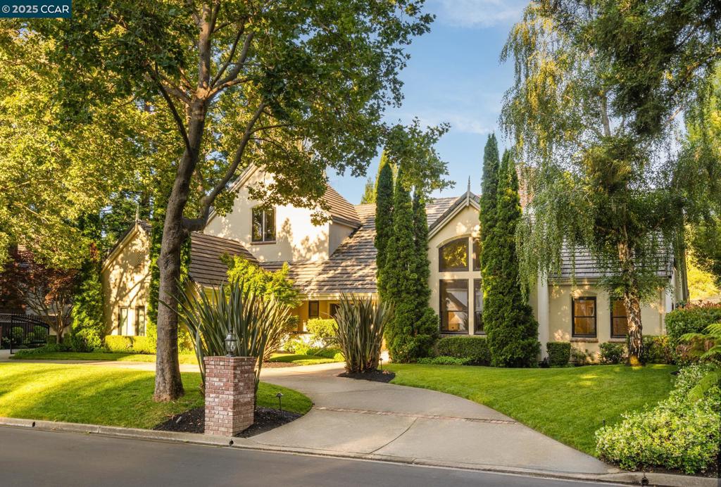 Located within the exclusive gates of Blackhawk Country Club, this beautifully upgraded 4,274 sq ft residence showcases over $600K in refined enhancements. Rich hardwood floors, designer lighting, and elevated finishes flow throughout. The formal living room impresses with soaring ceilings and picturesque windows, while French doors in the dining room open to an enclosed patio, blending indoor and outdoor living. The expansive family room connects seamlessly to a remodeled chef’s kitchen featuring Sub-Zero, Wolf, and Cove appliances. A cozy breakfast nook with built-in window seating, coffee bar, and backyard access add charm and convenience. The main level offers two secondary bedrooms, a shared bath, and a junior suite with ensuite bath featuring direct pool access. Upstairs, the luxurious primary suite boasts vaulted ceilings, automated shades, a sitting/office area, and a walk-in closet with a custom California Closet system. A large bonus room with built-in cabinetry and shelving provides flexible space for a media room, gym, or additional office. Outdoors, enjoy a circular driveway, gated entry, turf lawn, patios, and a solar-heated pool—backed by serene privacy with no rear neighbors. Enjoy premier country club amenities, top-rated schools, and nearby shopping and dining.