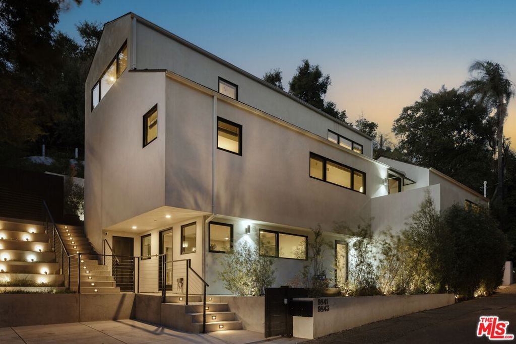 Step into the epitome of luxury living and stunning design in this spectacular Beverly Hills residence, complete with a thoughtfully crafted ADU. The interior has been completely renovated and its elegant design was recently featured in the Hollywood Reporter. Every detail has been meticulously curated to create a space that is both stunning and functional. Tucked away on a quiet and private street, this peaceful home is designed around a seamless indoor-outdoor flow so you can really appreciate the magical landscaping. Wide plank oak floors lead you through an expansive open floor plan, with walls of glass allowing natural light to flood the home and provide a picturesque backdrop. Host unforgettable gatherings with multiple al fresco dining and entertaining spaces connected to a gourmet kitchen and spacious living room. As you ascend to the top floor, you'll discover a primary suite, boasting a tall ceiling and expansive window panels that frame the terraced hillside. This private enclave includes a generous primary bath, a large walk-in closet, and a built-in workspace - all enveloped by the tranquil view of the lush backyard. The lower level presents a 1b1b (included in total bedroom/bathroom count) 700+ square foot ADU with its own direct mailing address, W/D hookup, walk-in closet, and gated parking that's separate from the 2-vehicle carport. Don't miss the opportunity to visit this extraordinary residence firsthand - it's a true gem that must be seen to be fully appreciated.