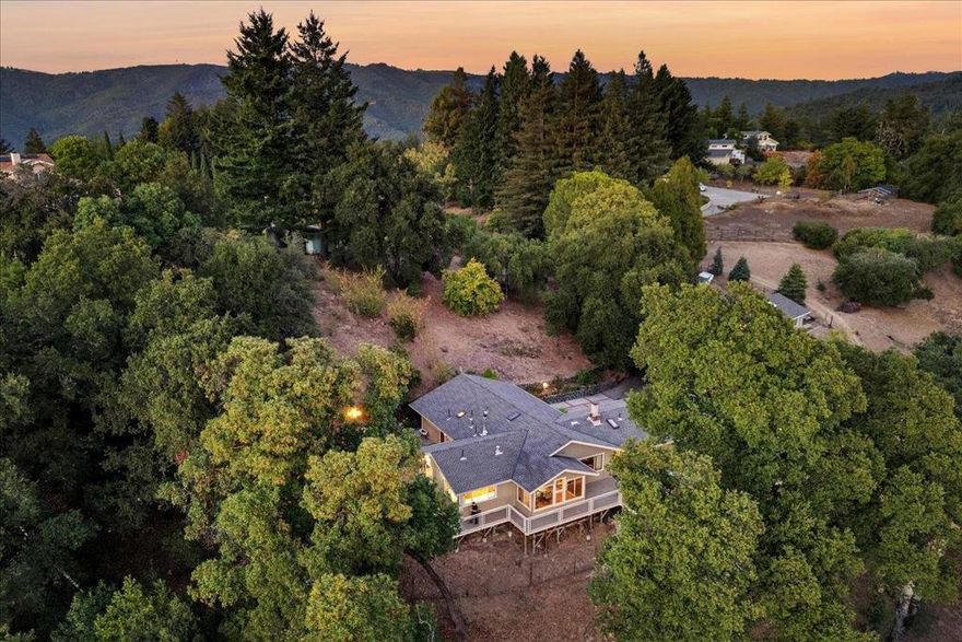 A tranquil retreat with views and privacy on 5.69 acres! Sip coffee on the deck while watching the fog lift over the bay or cozy up by the fireplace! This home is nestled in nature yet only 15 minutes from downtown Los Gatos and 25 minutes to Santa Cruz beaches. Lovingly built and maintained by one family! Gleaming hardwood floors; a gorgeous updated kitchen where you can look out at the squirrels and birds. A multi-purpose craft/sewing room with loft, large tiled sunroom can serve as a stunning dining room. The small private vineyard and orchard currently hosts both wine and table grapes and several varieties of fruit trees including: apple, pear, peach, fig, persimmon, lemon, plum, orange and pomegranate. The abundant garden space is ready for your winter veggies! The property includes 10,000 gallons of water storage; an adorable tree-house and ample outdoor entertaining space as well as parking for several vehicles and an RV.   Located in award winning school districts & an easy commute to both Silicon Valley or Santa Cruz. A large 24x48 workshop is complete with an oversized door, air compressor and its own bathroom. Over 3 acres fenced with a gated entrance ensures privacy and peace. An adorable playhouse overlooks the orchard. This property has something for everyone!