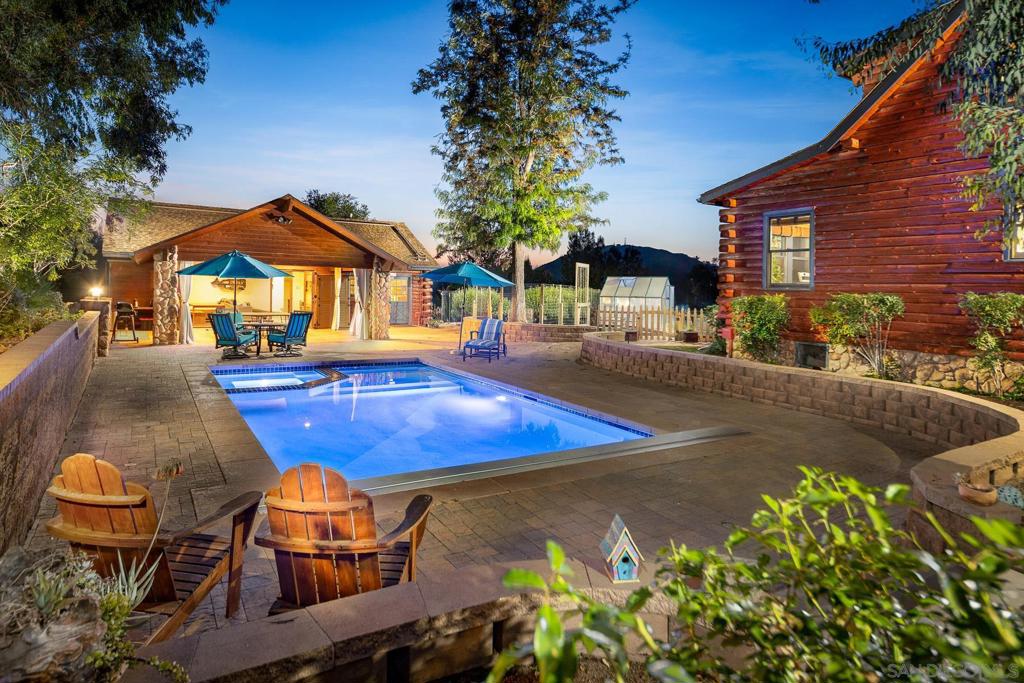 3 units!!! Escape to Your Dream Country Retreat: A Multi-Generational & Equestrian Paradise. Welcome to a truly unique offering in Valley Center – a sprawling, self-sufficient estate designed for harmonious country living, ideal for multi-generational families, animal enthusiasts, or those seeking a private sanctuary. At the heart of this remarkable property stands a 2,610 sqft Marysville Log Cabin, exuding rustic elegance. This inviting main residence features 3 spacious bedrooms and 2.5 bathrooms, ensuring comfort and privacy. Enjoy the perfect climate control with central HVAC, or gather around the charming wood-burning stove for cozy winter evenings. Adding to the property's incredible versatility are two additional, fully appointed living units. The charming approximately 500 sqft ADU provides a private haven with 1 bedroom, 1 bathroom, a full kitchen and its own washer and dryer, ensuring complete independence. A dedicated mini-split unit keeps it comfortable, while a delightful deck offers picturesque views, perfect for overseeing your beloved animals. For guests or extended family, the 900 sqft pool house is a true gem. This generously sized space includes a comfortable 1 bedroom and a full bathroom, along with its own central A/C. An attached storage room provides ample extra space for your needs. Step into your private outdoor oasis! The sparkling saltwater pool is the centerpiece of a magnificent entertaining area. Collectively, the property boasts approximately 800 sqft of covered patio space, creating an enchanting environment for al fresco dining, lively gatherings, or simply unwinding in the shade, truly a "paradise oasis in the country." Beyond the luxury and comfort, this property is engineered for efficiency and sustainability. Solar panels significantly reduce electricity bills, while Tesla Powerwalls ensure consistent, reliable power year-round. Water collection is a breeze with strategically placed holding ponds, rain gutters, and substantial 5,000-gallon and 2,500-gallon water storage tanks. For the animal lover, this fully fenced 4.65 acre estate is a dream come true! Equipped with a 75'x115' arena, three comfortable stalls, a dedicated hay barn, and a convenient tack shed, all your equestrian needs are met. Plus, there's ample extra space, inviting further growth and customization for your animal companions. This is more than just a home; it's a lifestyle. Discover the perfect blend of rustic charm, modern amenities, and unparalleled functionality in this Valley Center gem.