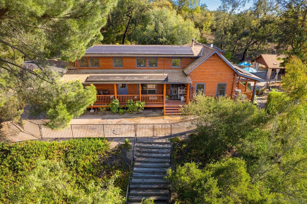 3 units!!! Escape to Your Dream Country Retreat: A Multi-Generational & Equestrian Paradise. Welcome to a truly unique offering in Valley Center – a sprawling, self-sufficient estate designed for harmonious country living, ideal for multi-generational families, animal enthusiasts, or those seeking a private sanctuary. At the heart of this remarkable property stands a 2,610 sqft Marysville Log Cabin, exuding rustic elegance. This inviting main residence features 3 spacious bedrooms and 2.5 bathrooms, ensuring comfort and privacy. Enjoy the perfect climate control with central HVAC, or gather around the charming wood-burning stove for cozy winter evenings. Adding to the property's incredible versatility are two additional, fully appointed living units. The charming approximately 500 sqft ADU provides a private haven with 1 bedroom, 1 bathroom, a full kitchen and its own washer and dryer, ensuring complete independence. A dedicated mini-split unit keeps it comfortable, while a delightful deck offers picturesque views, perfect for overseeing your beloved animals. For guests or extended family, the 900 sqft pool house is a true gem. This generously sized space includes a comfortable 1 bedroom and a full bathroom, along with its own central A/C. An attached storage room provides ample extra space for your needs. Step into your private outdoor oasis! The sparkling saltwater pool is the centerpiece of a magnificent entertaining area. Collectively, the property boasts approximately 800 sqft of covered patio space, creating an enchanting environment for al fresco dining, lively gatherings, or simply unwinding in the shade, truly a "paradise oasis in the country." Beyond the luxury and comfort, this property is engineered for efficiency and sustainability. Solar panels significantly reduce electricity bills, while Tesla Powerwalls ensure consistent, reliable power year-round. Water collection is a breeze with strategically placed holding ponds, rain gutters, and substantial 5,000-gallon and 2,500-gallon water storage tanks. For the animal lover, this fully fenced 4.65 acre estate is a dream come true! Equipped with a 75'x115' arena, three comfortable stalls, a dedicated hay barn, and a convenient tack shed, all your equestrian needs are met. Plus, there's ample extra space, inviting further growth and customization for your animal companions. This is more than just a home; it's a lifestyle. Discover the perfect blend of rustic charm, modern amenities, and unparalleled functionality in this Valley Center gem.