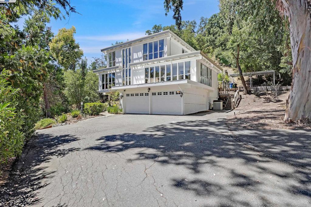 Discover over an acre of serene privacy in the heart of Alamo with this mid-century modern gem. Floor-to-ceiling windows fill the home with natural light, showcasing timeless architecture and lush views. The main entry opens to a ground-level foyer, with stairs leading to the second level featuring formal living and dining rooms, a cozy family room, and an updated kitchen with a center island, stainless steel appliances, and abundant cabinetry. The top level offers four bedrooms, two bathrooms, and a spacious primary suite with a walk-in closet. Step outside to a private backyard retreat with a sparkling solar heated pool and patio area. A short trail leads to a fenced upper area with a barn, including two stalls, a tack room, and a feed room—perfect for equestrian or hobby use. Additional highlights include a two-car garage, covered carport, ample parking, and potential for expansion. A rare opportunity with endless possibilities in one of Alamo’s most sought-after locations.