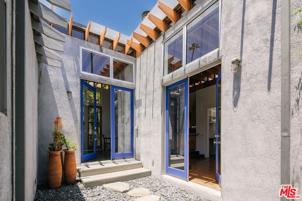 Set back on a quiet corner lot in one of the most desirable pockets of Venice, two distinct homes stand side by side, each with its own character, charm, and each completely private. The first is a 1,309 SF 2 BR + 2 BA home that perfectly captures the effortless cool of Venice, where architectural design and coastal charm converge. As soon as you step inside, the soaring vaulted ceilings with clerestory windows invite the sky in, and subtly infuse the space with natural light. The airy ambiance is matched by warm materials throughout: light oak as well as cork flooring, whitewashed walls, and slate tiled countertops. The open floor plan effortlessly connects the living room, cozy reading or TV nook, dining area, and kitchen anchored by a beautifully curved counter creating a seamless flow ideal for both quiet evenings and effortless entertaining. 8 foot glass doors lead you to outdoor decks and patio areas, blurring the lines between indoor and outdoor living. Each of the two spacious bedrooms is its own retreat: the ensuite offers access to a private outdoor area, while the second opens out to its own deck. Every space in the home feels both expansive and intimate, and its overall thoughtful design emphasizes the connection to both the outdoors and Venice's laid-back, artistic style. The second home, a 432-square-foot Traditional, exudes warmth as soon as you walk through the gate into a charming enclosed front yard. Inside, a cozy yet open living and dining area flows into the kitchen, and the single bedroom, basking in soft light, offers comfort and calm. The 2 BR home is vacant with a recent market rent of $6,800, while the 1 BR is tenant occupied at $3,500 per month, making this not only a unique living opportunity, but a smart investment as well. Two homes, one lot, endless possibilities: live in one, rent the other; share with family; or enjoy as a peaceful, income-producing Venice mini-compound.