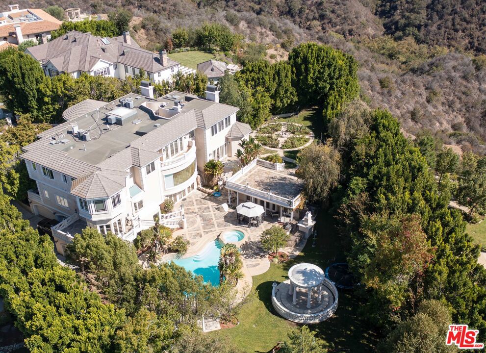 Located in the prestigious Guard Gated Community of Bel Air Crest. This rare trophy property offers privacy and canyon views out to the ocean. An extraordinary double lot with one of the largest backyards in any A+ gated community outside of Beverly Park. This developers dream property is the epitome of value-add or reposition and keep the current tenant who is outside of their lease. Situated on almost 12,000 S/F of livable space the property sits on over a full acre of land. Enjoy an inspired waterfall and bridge that lead to gardens and a beautiful pool, a large pool house and gazebo.This custom-built home with (7) bedroom suites and a primary bedroom with two baths and walk in closets is wonderfully though out. The property has a stunning floorplan that opens up to a double staircase with spacious rooms and expansive glass windows, theater, game rooms, elevator, gourmet kitchen with flowing staircases. The front of the property is set back behind gates featuring a generous motor court and garage that accommodates (6) cars. Community has tennis courts, gym, club house, playground and putting green. This unique opportunity to 1031 exchange with a strong existing cashflow or develop is impressive and unusual. Photos are no longer current but represent the property as it was originally presented. Showings will be on Mondays, Wednesdays, and Fridays 1-5pm.