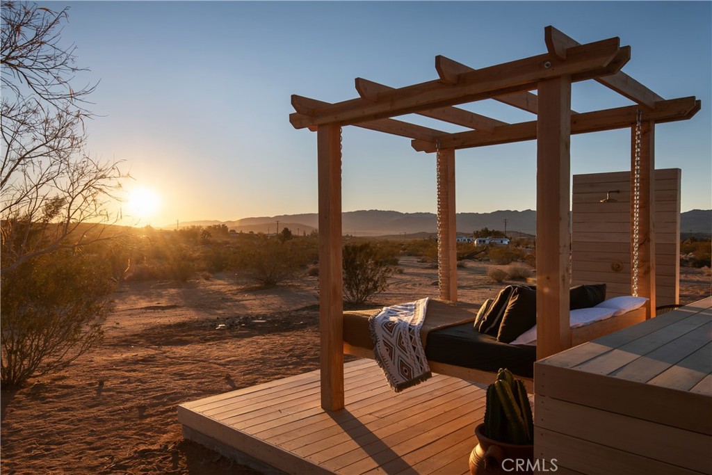 Remodeled functioning airbnb home with converted garage on approx. 2.5 acres in Joshua Tree. Entre into this open floor plan
with sliding glass doors and plenty of windows to draw in the serene mountain views. Beautifully appointed kitchen with butcher
block countertops, stainless steel appliances, and a breakfast counter for casual dining. A custom barn style door leads to the bathroom, which
features newer fixtures, dual sinks and gorgeous subway tile tub/shower combo with glass door. Primary bedroom, with its own mini-split
and a sitting area offering private sliding door access to the back patio. Fully finished converted garage, which is currently
being used as a second bedroom and could also be a game room, studio, etc. The sleek Avanti custom
garage door has translucent panels. This bonus room offers polished concrete floors, its own sliding door leading out to the backyard. Washer/Dryer and secondary storage closet. Picturesque rear yard with wooden back deck and shade ramada which enjoys stunning views of the Joshua Tree mountains. Outdoor kitchenette with BBQ grill, Fire pit, Hammock, Hot tub, Outdoor dining area, Outdoor furniture, Outdoor kitchen,Outdoor shower,Sun loungers, Movie theater and an above ground pool with deck.
