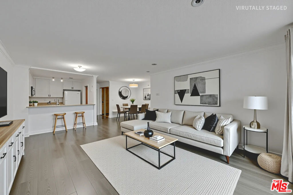 Welcome to this beautifully updated 1-bedroom, 1-bathroom condo spanning 853 sqft in the prestigious Promenade Building, located on the 4th floor. This bright and airy unit features fresh interior paint throughout most of the home, enhancing its modern appeal. The open living area boasts elegant flooring, smooth ceilings, and custom crown molding, creating a sophisticated yet inviting atmosphere. The spacious bedroom offers ample closet space and a serene retreat, while the bathroom showcases tasteful tilework and a sleek modern vanity with a stylish sink. Standout feature is the enclosed patio, thoughtfully transformed into a private study or reading nook, perfect for enjoying the lush green views. The well-appointed kitchen includes a refrigerator, ample counter space, and cabinetry, seamlessly connecting to the living area for easy entertaining. Residents of the Promenade enjoy unparalleled amenities, including a pool, spa, fitness center, sauna, 24/7 security, concierge services, on-site management, fiber internet, and generous guest parking. With one assigned parking space included( #144), convenience is at your fingertips. Perfectly situated across from the Disney Concert Hall, this condo is near by cultural landmarks like The Broad, MOCA, Dorothy Chandler Pavilion, and Ahmanson Theater. Enjoy top dining, Grand Central Market, and easy access to Dodger Stadium, Crypto Arena, major freeways, and the Bunker Hill metro station. Experience luxury living in the heart of Downtown LA! Home is virtually staged.