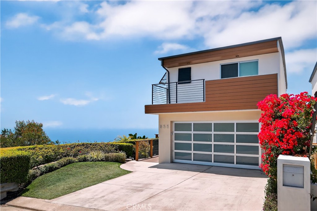 Located at the end of a private cul-de-sac atop Arch Beach Heights, this striking split-level contemporary residence offers unobstructed 180-degree ocean and coastline views, with Catalina Island and twinkling city lights stretching beyond Laguna Beach, visible from nearly every room. Set on an exceptionally rare double-wide lot, the home spans nearly 2,350 square feet and features 4 bedrooms, 3.5 baths, a dedicated office (optional 4th bedroom), a private theater, and a custom wine room. Originally reimagined in 2007 by acclaimed designers Anders Lasater and Mark Singer, the home blends bold design with timeless quality. The spacious primary suite includes a custom-built closet system and an expansive spa-like bathroom complete with a steam shower, soaking tub, and a built-in TV for the ultimate retreat. Upstairs, the main living area boasts an open-concept layout with hardwood and stone flooring, a chef’s kitchen with stainless steel appliances—including a Bosch ultra-quiet dishwasher—cherry wood cabinetry, granite counters, skylights, a breakfast bar with a mini-fridge, and a center island cooktop. Sliding doors lead to both front and rear decks, seamlessly extending the living space outdoors. This exceptional property offers the rare combination of architectural sophistication, functional design, and breathtaking natural beauty. Just moments from world-class beaches, hiking trails, restaurants, and vibrant village life, this home is not only a peaceful retreat but also a gateway to the very best of coastal living. Whether you're entertaining guests or enjoying a quiet evening overlooking the Pacific, this one-of-a-kind residence delivers an unparalleled lifestyle experience.