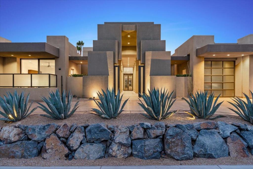 This magnificent home embodies modern desert luxury. From the moment you step through the elegant promenade entrance and into the atrium framed by a custom glass and iron door, you're welcomed by soaring 15-foot ceilings and an open layout that seamlessly blends formal and informal living. Walls of motorized Fleetwood vanishing pocket doors disappear to reveal a stunning travertine-tiled patio with pool, spa, fire pit, and eat-in BBQ island -- perfect for indoor-outdoor living on the 17th hole of the Pete Dye Course. For the most discerning chef, the gourmet kitchen is equipped with Sub-Zero, Wolf, and Fisher & Paykel appliances. The Primary Suite is a private sanctuary, featuring a custom motorized wall that opens directly to the pool, dual luxe closets, coffee and beverage bar, and a spa-inspired bath with a soaking tub and direct access to a tranquil courtyard complete with a fireplace and fountain. Each of the four en-suite bedrooms feature floor-to-ceiling Fleetwood sliders that open directly to the outdoors for a seamless connection to the surrounding landscape. Guests will appreciate the privacy of the en-suite casita, complete with its own refreshment lounge. Additional features include 60-panel owned solar with a grandfathered utility rate, smart home technology, motorized windows and window treatments, brand-new Sub-Zero Refrigerator and Fisher & Paykel dishwashers, two new A/C units, a garage splitter, and so much more! (See attached list.) Offered furnished, this contemporary home is desert living at its finest.