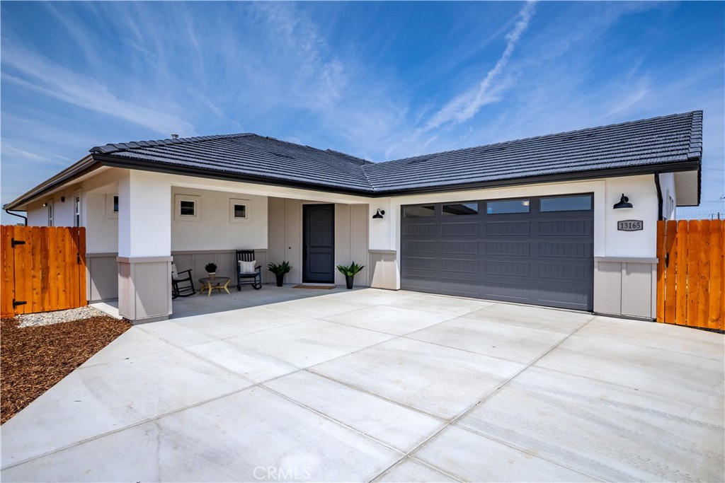 Experience the art of modern living in this breathtaking, newly constructed single-level home - where every detail has been curated for comfort and convenience. Spanning approximately 2,376 square feet, this 4-bedroom, 2.5-bathroom residence welcomes you with a sense of crisp sophistication and fresh, open design. From the moment you enter, you’re embraced by natural light and a captivating view. Flowing effortlessly throughout, Luxury Vinyl Plank floors stretch throughout the home, setting the stage for a lifestyle of ease and beauty. The formal living room opens gracefully into an expansive layout that unites the dining area, family room, and chef’s kitchen - designed for gathering, entertaining, and everyday use. The heart of the home is the gourmet kitchen, a culinary dream featuring sleek stainless steel appliances, a gas cooktop with stylish hood, and a generous quartzite stone island with bar seating. Whether it’s a festive celebration or a cozy night in, the open-concept family room, with its elegant gas fireplace, invites warmth and togetherness. Step outside through oversized sliding doors to a covered patio that reveals panoramic views of rolling hills and bluffs overlooking the riverbed and town of San Miguel - a fabulous backdrop for outdoor dining or sunset evenings. The backyard offers privacy fencing and is thoughtfully landscaped for low maintenance, and is the perfect canvas to make your own. The primary suite is a true sanctuary, bathed in natural light with a picture window framing the beauty of nature. The suite includes a spacious walk-in closet with custom built-ins and a spa-inspired en suite bath featuring a white double vanity with quartz countertops, striking matte black fixtures, and a walk-in tiled shower with dual showerheads, including a rain showerhead, and a built-in bench. Three additional spacious bedrooms and a stylish powder bath ensure space and comfort for guests and loved ones, while a second full bath - with its own double vanity and custom shower - offers luxury at every turn. There is even room on the side of the house for oversized vehicle parking and owned solar panels for efficiency. Set within a serene gated community just minutes from Paso Robles, Highway 101, local wineries, and charming restaurants, this is more than a home - it’s a fresh beginning, a place to live fully, and a space where lasting memories are made. Come make it your own.