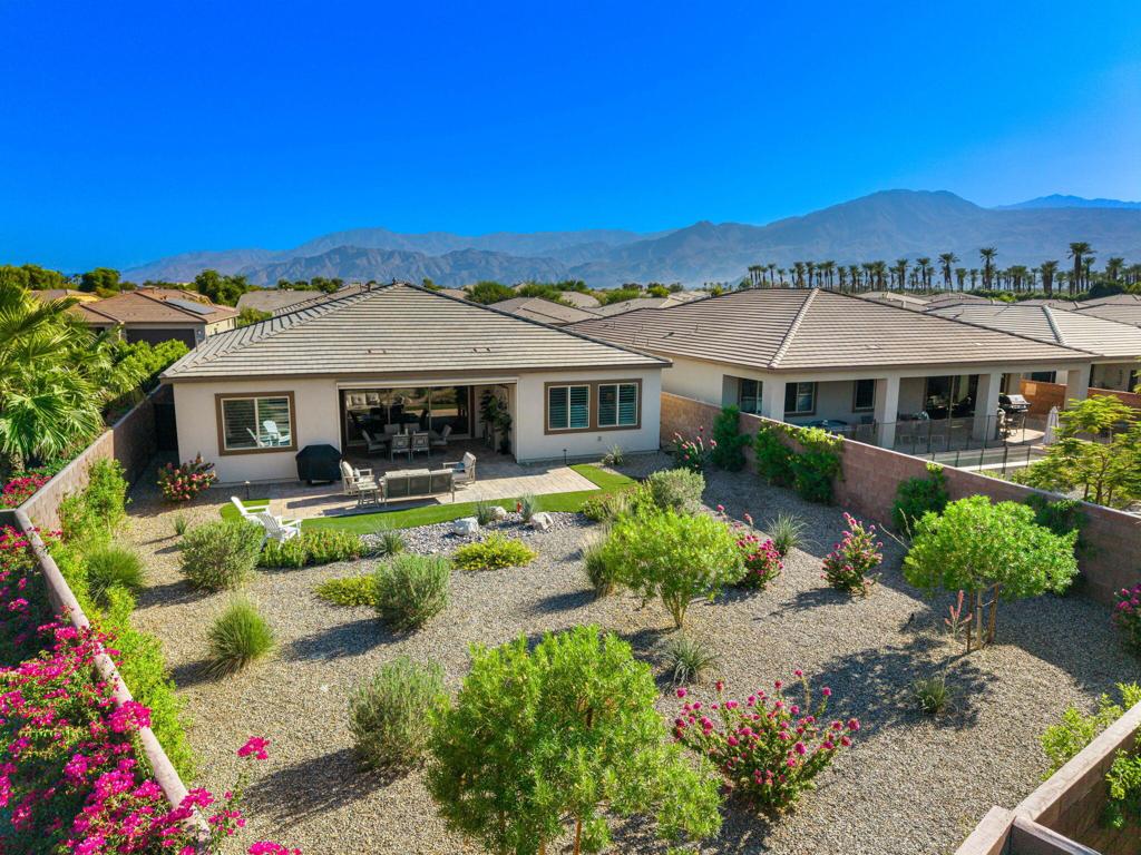 Welcome to this impeccably maintained and thoughtfully upgraded Proclaim Plan residence, ideally located behind the private gates of the prestigious Trilogy Polo Club--a premier active lifestyle community. From the moment you arrive, the curb appeal impresses with a beautifully designed paver driveway leading to a custom smoked-glass front entry door, setting the tone for the elegance found within. This spacious and versatile floor plan features a dedicated 3 bedroom, 2.5 bath with den/office that can easily serve as a fourth bedroom, seamlessly flowing into a light-filled great room that exemplifies open-concept living. Soaring ceilings, wide-plank flooring, 5-inch+ baseboards, plantation shutters, and abundant natural light create an ambiance of casual sophistication. Dual sets of pocket sliding glass doors extend the living space outdoors, revealing an expansive covered patio adorned with a paver deck and equipped with drop-down sun/privacy shades--ideal for al fresco dining or entertaining guests in style. The adjacent formal dining area complements the gourmet kitchen, which showcases quartz countertops, a large prep island with bar seating, custom backsplash, ample white cabinetry with brushed nickel hardware, and a suite of high-end stainless steel appliances, including a built-in refrigerator, wall ovens, 6-burner gas cooktop with a custom range hood. The private primary suite serves as a tranquil retreat, featuring a generously sized bedroom, luxurious en suite bath with dual vanities, quartz surfaces, a walk-in closet, and a striking floor-to-ceiling tiled walk-in shower. Multiple guest accommodations provide comfort and privacy for visitors, while a separate laundry room with built-in cabinetry and a utility sink adds convenience. Additional enhancements include 15 solar panels for energy efficiency, a golf cart garage, and professionally designed low-maintenance landscaping that creates a serene outdoor atmosphere. This exceptional home is the epitome of luxury desert living--schedule your private tour today to experience it firsthand.