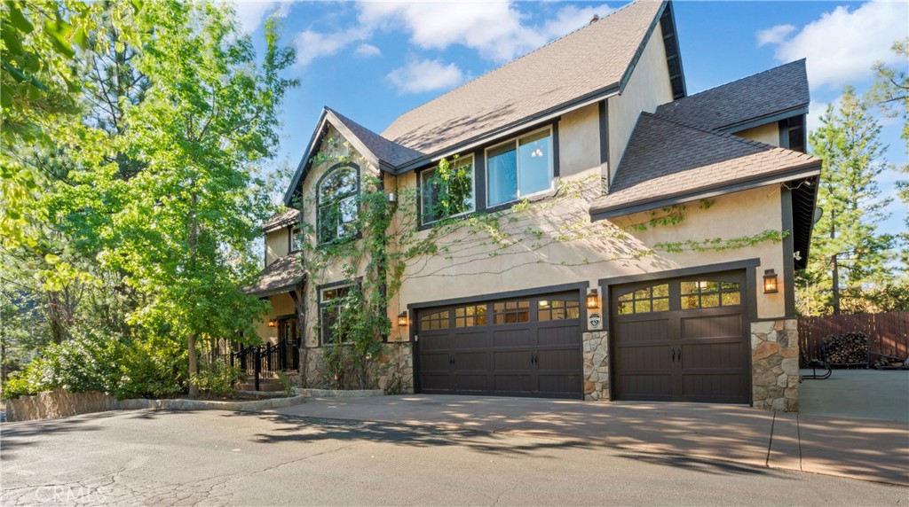 Full lake rights to private Lake Arrowhead, 1034 Teakwood is a impressive, quintessential mountain lodge one dreams of for hosting family holidays in Lake Arrowhead! Custom built for the original owner in 2005, the builder maximized every bit of space within this spacious LEVEL corner parcel. No detail was overlooked utilizing high quality finish work carpenters and high quality lighting fixtures/hardware throughout. Driving into the property you will appreciate hand chiseled split faced granite retaining walls and planters. Level parking galore with ample space for a BOAT AND RV PARKING next to the oversized/extra deep 3 car garage! There’s also a shed to house the snow blower and tools. Reside in a low maintenance house through plaster siding, Trex decking and custom metal decking handrails. Maximum comfort provided by central forced heat and A/C plus Sellers recently installed a 24KW Generac whole house natural gas generator! The perfect property for kiddos and pups frolic within the fenced yard with artificial turf. A grand front door entrance greets you with a dramatic foyer boasting hand carved beams, banister, and rustic door/window casings. Solid wood flooring blankets the entire main living level. A spacious bedroom and full bathroom conveniently located on the entry floor! The kitchen is tastefully designed with knotty pine cabinetry, stainless appliances, double oven, custom mountain theme tiled backsplash, coffee bar, center island, and breakfast bar top. Relax fireside in the vaulted ceiling living room which leads directly onto the oversized entertaining deck(Trex). Upstairs hosts a luxurious primary en suite bedroom with floor to ceiling romantic dual sided stone fireplace, vaulted ceilings and huge walk in closet. Pamper yourself in an oversized soaking tub and enclosed glass shower beneath beautiful skylights. The upstairs is completed with the laundry room, 2 guest bedrooms, a double sink vanity bathroom. The loft serves as an office or movie room, or, frame it in to create a 5th sleeping quarters. With Arrowhead’s steep topography, this well maintained property truly is a rare find for its flat usable grounds. Listed just in time for the holiday season, make it a must see today!